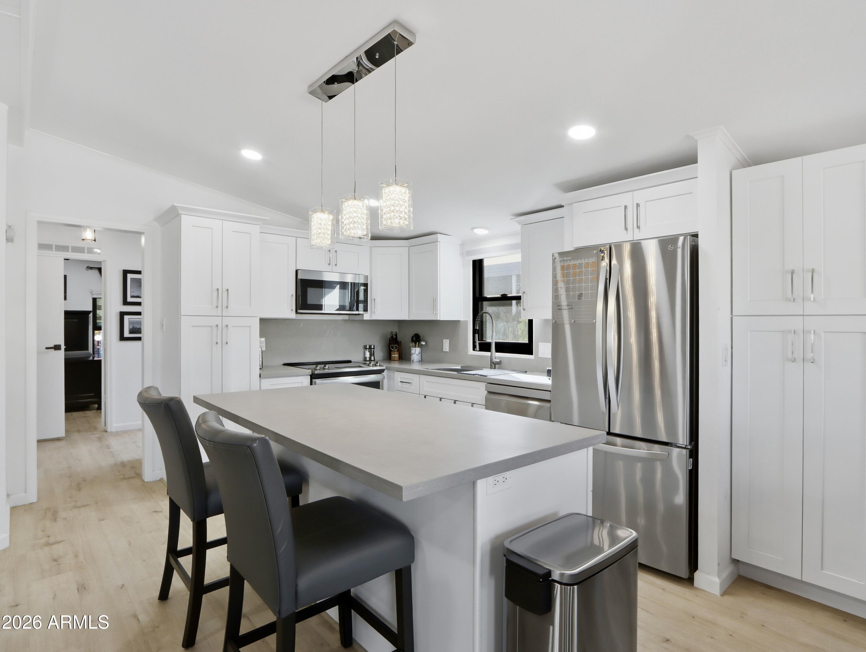 Be impressed by this fully transformed home with sleek, contemporary finishes inside and out. This 2-bed, 2-bath residence in the gated 55+ Boulder Ridge community feels brand new. Desert landscaping welcomes you along with two covered carport spaces and a storage unit. Inside, vaulted ceilings and an open layout create a bright, airy feel. Features include high-end flooring, 18 modern light fixtures with recessed lighting, a window seat, and a neutral color palette. Improvements: $30K+ Andersen window package installed in 2024 with transferable warranty. 2022: HVAC & Hot water tank. Roof replaced 2023. Vents cleaned 2025. Buyer must be park approved: 750+ credit score, 3x lot rent in verifiable income, proof of savings equal to 6x lot rent, and background check. Lot rent $1,010/month. Natural light floods the home, offering delightful views of the neighborhood and majestic mountains beyond. The gourmet kitchen is a chef's dream, equipped with sleek stainless steel appliances, durable solid-surface counters, and high-quality soft-close white shaker cabinets adorned with elegant crown molding. The focal point is the expansive island with a convenient breakfast bar, perfect for gathering with friends and family. The large main bedroom features a walk-in closet and an ensuite with a vessel sink & a tiled walk-in shower. Relax & entertain the guests in your cozy wrap-around deck! The resort-style Community amenities are waiting for you to enjoy. So don't miss the opportunity to make this impeccable home your own. It's an ideal canvas to create your perfect retreat, blending modern elegance with comfort and functionality. 

Located in the serene landscape of North Phoenix, this notable property is a gem within the premier 55+ active adult community of Boulder Ridge. Exhibiting exemplary cleanliness and expert management, this exclusive, gated sanctuary homes a collection of 263 exquisite residences, providing an atmosphere of utmost comfort and security.

The community bestows upon its residents numerous deluxe resort-style amenities. These include, but are not limited to, two inviting heated swimming pools and separate heated spa, fitness center, a dynamic multi-sport court inclusive of Pickleball, engaging hiking trails, and an elegantly furnished clubhouse.

Boulder Ridge is designed to accommodate a range of lifestyle choices, emerging as an ideal option for both year-round dwellers and seasonal visitors. The added convenience of on-site RV/boat parking caters to the requirements of residents owning mobile leisure vehicles, adding to the community's allure. Indeed, it presents a distinguished residential prospect well worth exploring.