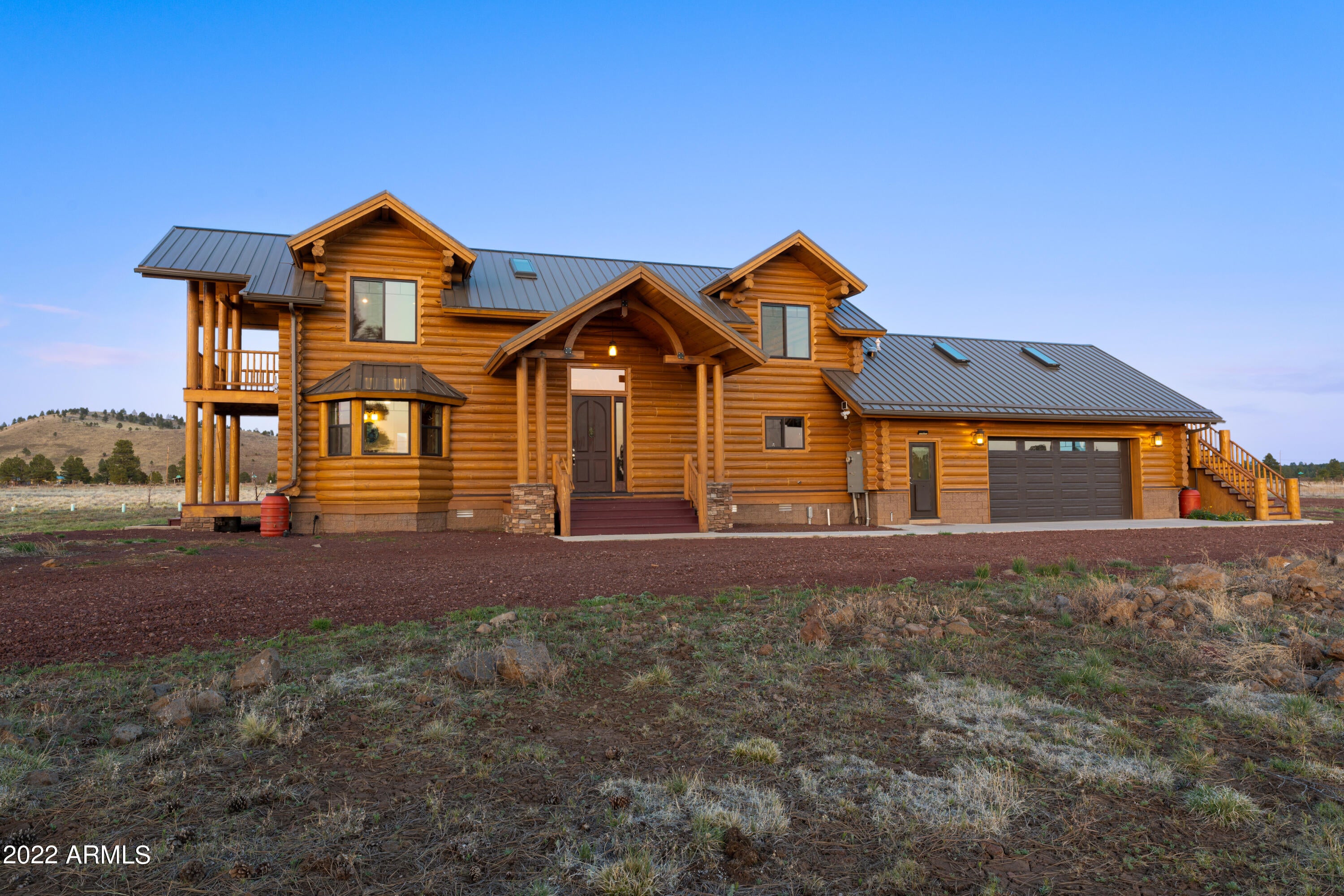 A spectacular 2800 ft , 3 bed, 3 bath, 2 car garage Custom Built in 2013 log cabin with a 2700ft detached RV garage awaits you with amazing views of the San Francisco Peaks as a primary or secondary home. With NO HOA and 10 acres completely fenced next to each other in 5 Acre sections with two separate private entrances you will have a plethora of space for horses, animals, ATVs, Side by sides, dirt bikes and all sorts of other outdoor activities! The cabin itself is air conditioned, with multiple covered patios, three different entrances, and an attached 2 car garage with newly epoxied floors. Vaulted ceilings throughout and natural lighting coming in during all times of day really make this home a great place to be. The cabin is constructed of high efficiency logs, with sprayed in insula insulation in both the roof and flooring. The home also boasts Low E thermal double pane windows and a rainwater catchment system with a 3000-gallon cistern. The wood burning fireplace ties nicely into the log cabin feel and provides plenty of warmth. The kitchen entails beautiful custom marble countertops throughout that nicely compliment the 48" WOLF double gas oven. The newly painted and epoxied floor for the 60x45' (2700 sq. ft. RV block garage with pull through doors and 200 amp service) is a nice touch. Some additional features include updated LED lightning, new toilets, interior painting, new pumps for cisterns, metal roofing on both the log home as well as the RV garage. With all of this being said it would be impossible to recreate this beautiful home for anywhere near this price given the current cost of labor and materials. Come view this property and make it yours before it's gone!