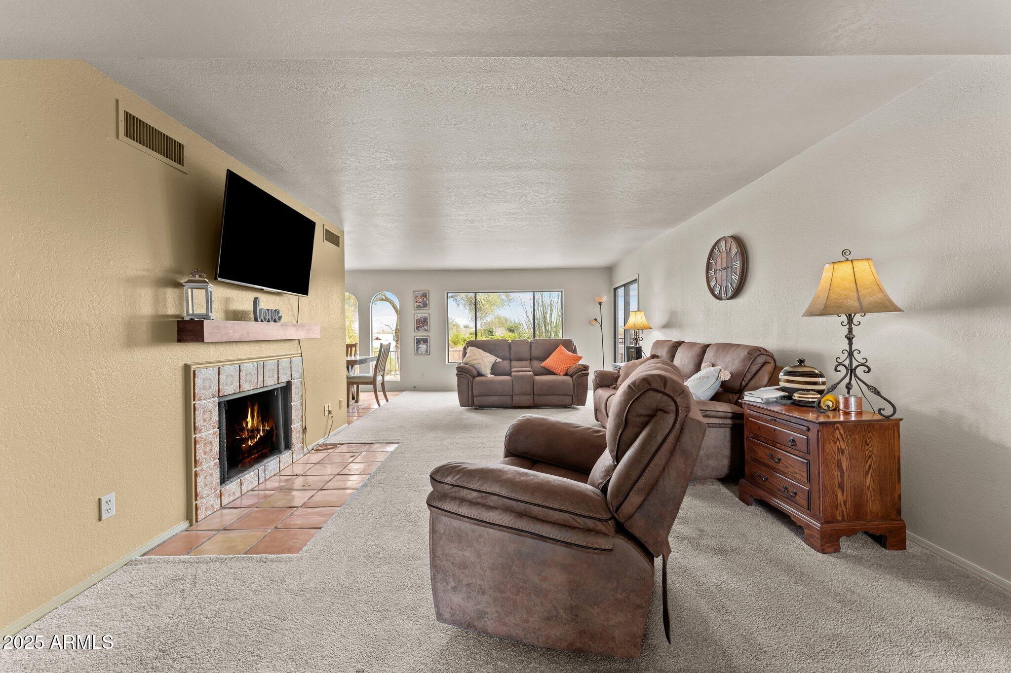 Fully furnished & freshly painted throughout, this spacious move-in ready villa offers 1,842sqft of comfortable living space w/ 3 bd & 2 bathrooms. The home features charming arched windows & a cozy fireplace with mantel, creating a warm & inviting atmosphere. The primary bedroom includes sliding glass doors leading to a private back patio where you can enjoy peaceful desert views, along w/ a large walk-in closet for ample storage.Additional highlights include a French door entry & an expansive laundry room w/ extra storage space. Outside, the property offers a 2-car carport w/  two outdoor storage areas.Conveniently located within walking distance to the Wickenburg Country Club, Safeway, Tractor Supply, & local restaurants, this home offers a great combination of comfort, & convenience.