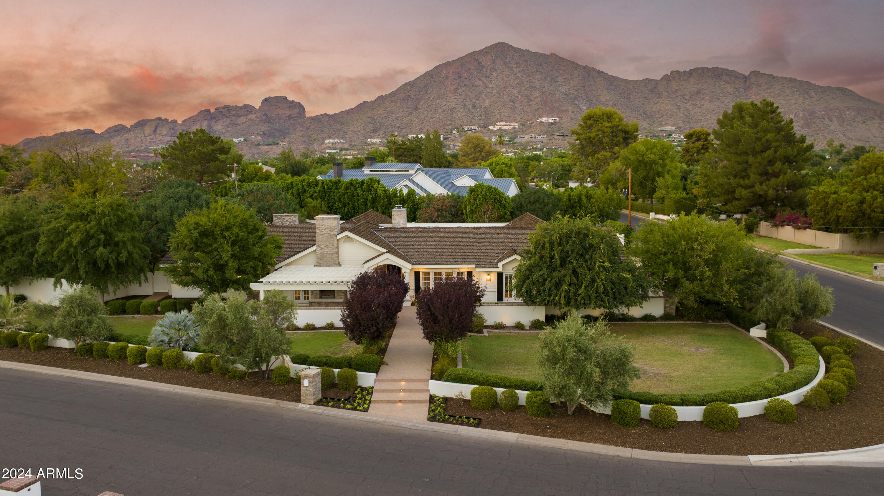 Remodeled in 2018, this stunning 6,100 sqft Arcadia Estate sits on just under an acre and is bursting with curb appeal with its lush landscaping and welcoming front porch pergola and classic red brick fireplace to greet guests. Thoughtfully designed, this split floor plan presents four spacious ensuite bedrooms including a primary suite designed with luxury and comfort in mind with his/her closets, a spa like bathroom featuring a stand alone tub, walk-in shower, double vanities and hand selected finishes throughout. The rest of the home features a formal living room, a grand family/game room with vaulted ceilings, a formal dining room, a library/office, and a bonus gym/storage room. The butlers pantry, with a temperature controlled wine room, connects the formal dining to an oversized eat-in kitchen which is a testament to traditional elegance boasting marble countertops, a large kitchen island, and top-of-the line appliances including a Wolf Range and a Sub-Zero refrigerator/freezer. A passthrough fireplace seamlessly connects the kitchen to the home's great room which includes a full bar and a stunning sliding door entrance to the backyard.

Designed for both relaxation and entertainment, the backyard retreat features lush landscaping, a diving pool that can be both heated and cooled, a built-in BBQ, and an elegant covered ramada that houses an outdoor fireplace creating a cozy ambiance for evening conversations and gatherings. To top it off, all your family and friends can have fun enjoying the in-ground trampoline, bocce ball court and a professional batting cage.

Walking distance to the coveted Hopi Elementary and in close proximity to Arcadia's most popular shopping and dining experiences, this is the perfect place to call home so you can live, work and play the Arcadia lifestyle.