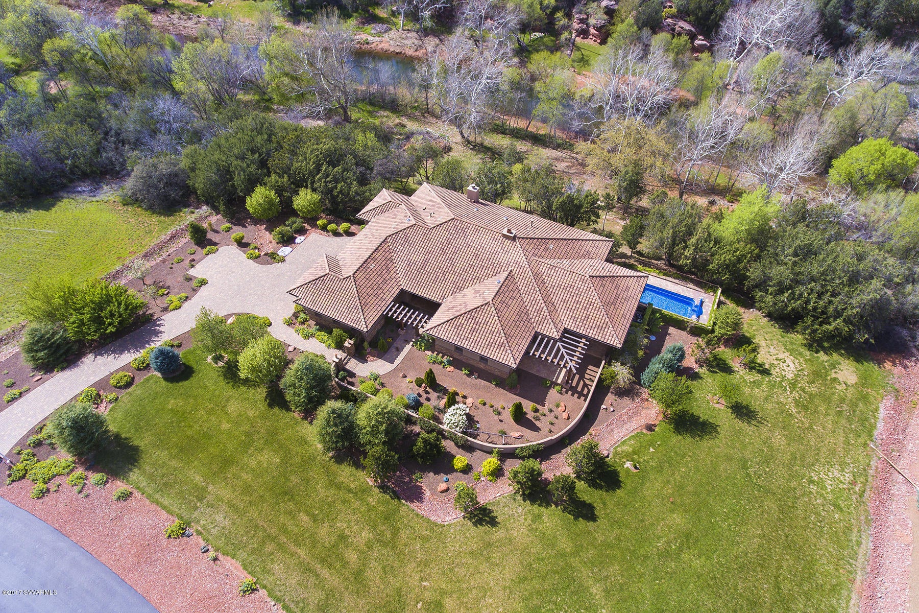 Prestigious location in Cross Creek Ranch a luxury gated community right on Oak Creek!  Sit back and enjoy the soothing sounds of Oak Creek and watch the water flow by from your large private patio with kiva. Dramatic courtyard entrance with beautiful custom 8 ‘ Brazillian mahagony front door. Three bedroom suites with private baths plus den.     High end amenities include hand scaped maple wood floors with low E Eagle wood windows made by Anderson.  Custom kitchen featuring Huntwood cabinetry with pullouts and self closing doors.  Granite counters with stainless steel appliances.   Huge walk in pantry.    Master suite draws your attention to the beautiful stone gas fireplace and views overlooking Oak Creek. Large shower with separate whirlpool tub. Storage is not a problem as this master has four closets. Two walk in plus two custom built with shelves and built ins.   Large linen closet. Two built in hutches. Three high efficiency HVAC units. Heated Pool . Three car garage. Patios off of each bedroom suite.   Pavered driveway. Low maintenance metal capped beams.  Irrigate your property from the historic Armijo ditch.  Water rights.  Direct access to Red Rock State Park.  Hiking trails.