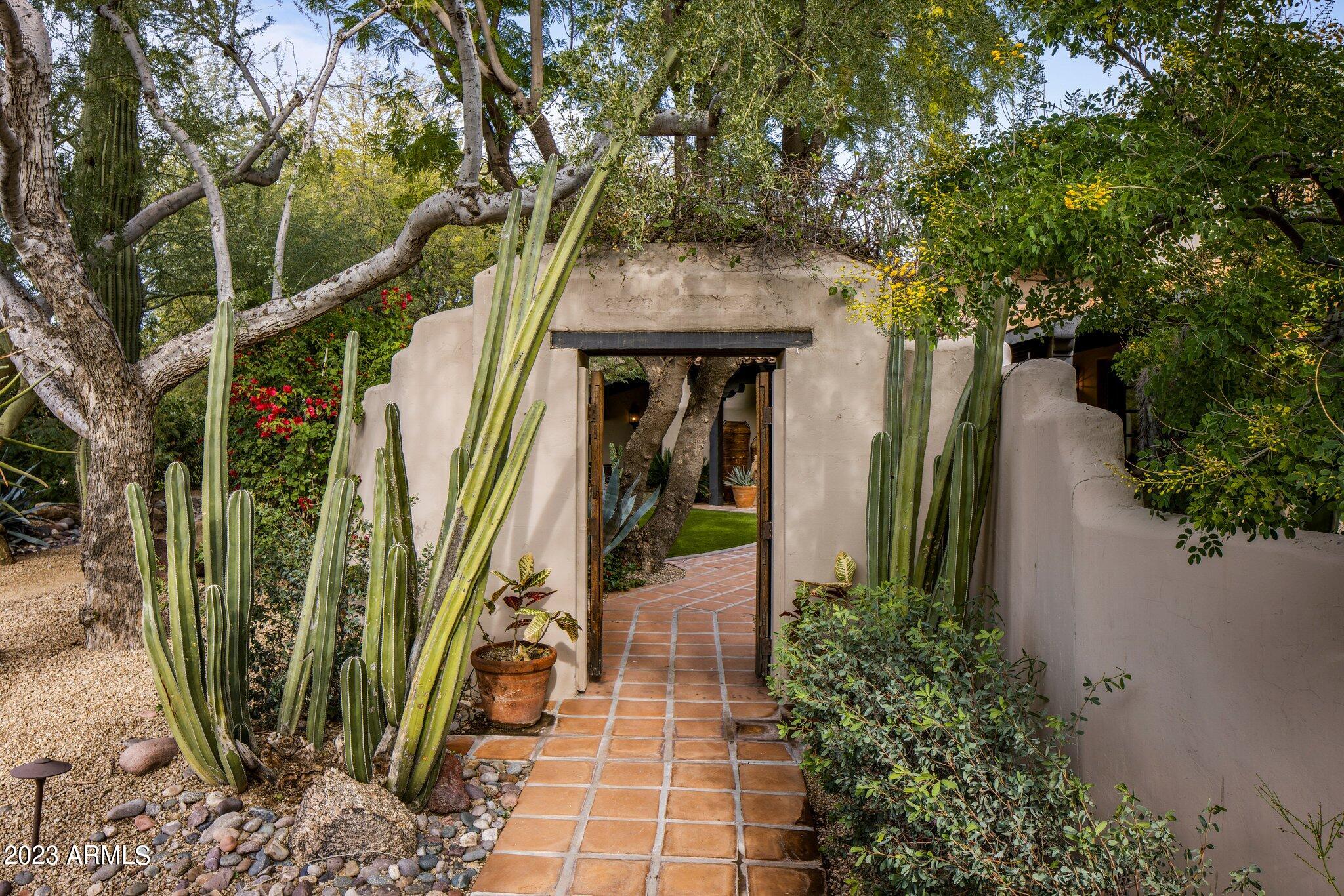 Authentic Southwest architecture abounds in this timeless one-of-a-kind masterpiece.  Designed by Lash McDaniel, a Phoenix Home & Garden's Master of the Southwest, and built by Kitchell, the stucco walls, and red tile roof set the stage for thoughtful architectural details and craftsmanship.  Imported Mexican wood doors, clerestory windows, ornamental ironwork, curved walls, arches, beamed openings, colorful tiles, and beautiful brickwork combine with intimate covered patios, airy outdoor living, and lush landscaped spaces to create a very special retreat. The prime location on an acre lot near Camelback Mountain is Arizona at its best.  You'll feel a world away while still being close to plenty of resorts, hikin Authentic Southwest architecture abounds in this timeless one-of-a-kind masterpiece.  Designed by Lash McDaniel, a Phoenix Home & Garden's Master of the Southwest, and built by Kitchell, the stucco walls, and red tile roof set the stage for thoughtful architectural details and craftsmanship.  Imported Mexican wood doors, clerestory windows, ornamental ironwork, curved walls, arches, beamed openings, colorful tiles, and beautiful brickwork combine with intimate covered patios, airy outdoor living, and lush landscaped spaces to create a very special retreat. The prime location on an acre lot near Camelback Mountain is Arizona at its best.  You'll feel a world away while still being close to plenty of resorts, hiking, golf, dining, and great shopping. It's the best of both worlds! 

A charming Saltillo tile walkway, a wooden privacy gate, and scalloped walls guide you to the front courtyard with a gracious fountain that creates an ambiance you can only find in far-off places. The heavy wooden front door expresses solidity with a dramatic stone surround that sets it apart from other façade openings and is protected with covered patios supported by traditional carved wood posts.  The heavy rustic wooden front door is surrounded by reclaimed stone and welcomes you to a hexagonal foyer with soaring ceilings with faux medallion, a gorgeous iron chandelier, and decorative iron clerestory windows.   The reclaimed French roof tile flooring flows throughout most of the house and even into the attached garage. 

The foyer opens to a spacious great room with clerestory windows, a large front window framed with incredible saguaro rib shutters, a stone surround fireplace, and beautiful double doors that open to a large, covered patio boast distinctive hardware and custom wooden screen doors so you can enjoy the fresh air all year long. A convenient bar with granite countertops, a brass shell sink, an undercabinet beverage refrigerator, an icemaker, a glass-shelved storage hutch, and a charming arched metal window overlooks the covered patio

Waiting outside is an abundance of entertaining spaces. The adjacent covered patio with carved wood posts shares the same reclaimed French roof tile floor as the home creating a seamless feel. Stucco banquettes with colorful pillows, ironwork chandeliers, and the charming arched bar window help to create this unique space accessible by the owner's bedroom, the great room, and a guest bedroom. As you continue out to the backyard towards the casita, you will find a large artificial grass area, lush landscaping, and an additional large vaulted and wood-beamed entertaining ramada created with scalloped walls, stucco banquettes, a gas fireplace, TV, grill, and dining area.   Flanking the casita is a 75-foot, tiled, salt-water lap pool and spa intentionally designed so that no individual tiles were cut.  Eight pillared spillways with ceramic tile, massive agaves, and planted urns adorn the lap pool. The backyard is complete under the watchful eye of the lion carved into the low wall separating the lap pool from the ramada. 

The dining room vaulted tongue and grove wood beamed ceiling continue the spacious feel of the great room while a faux-finished scallop shell motif niche adds a touch of Spanish influence to the home. Two large windows with saguaro rib shutters overlook the front courtyard.

An arched butler's station including a Sub-Zero wine refrigerator and a built-in Miele coffee station opens to a well-appointed kitchen with a stunning vaulted brick ceiling suspended above clerestory windows supported by rustic wood beams.  A stone-carved fireplace anchors the dining area and built-in desk while a stone-carved hood balances the 6-burner Wolff range with a griddle and pot filler.  The large center island with live edge granite boasts a large copper sink and room to gather.  Custom cabinets with iron-scrolled accents house SubZero, Viking, and Asko appliances. A spacious pantry, with a rustic arched wooden plank door, rounds out the kitchen and gives way to an enviable laundry room with a large arched window and desk overlooking the front courtyard and Camelback Mountain. The farm sink is framed in a stunning tiled arched opening and custom cabinetry offers great storage, a hide-a-way washer and dryer, and an integrated TV! Faux-painted niches and brick-arched ceilings guide you to the attached one of two 2 car garages through another beautiful wooden arched door. 

The owner's bedroom is located off the great room through enchanting wooden double doors with black wrought iron nail heads, decorative iron rope, and reclaimed door handles. Once inside the wooden floors give way comfortable space with a large sitting area and classic curved niches.  Double doors with plantation shutters open to a covered patio, entertaining spaces, and the 75 ft. lap pool.  The arched entrance to the primary bath highlights a stunning one-piece onyx bathtub set majestically in front of a large window overlooking a tranquil, lush, and private courtyard with a ceramic tiled fountain and outdoor shower.   Marble and onyx tile details and arches create balance and beauty while creating two separate sink areas, a separate commode with bidet, and a walk-in shower with accented ceramic tile, rain, and handheld showerheads, and access to the outdoor courtyard shower.  There are even heated floors! Two spacious separate closets with extensive built-ins and decorative skylights finish off this tranquil owner's retreat.  

Another set of unique wooden double doors off the foyer open to the office with a kiva fireplace and a window seat banco that overlooks the front patio. These classic design elements combine with high ceilings, built-in bookshelves, and double doors that open to a private covered patio with carved wood posts to create a very special space.  

The office accesses a large bathroom that connects to an adjoining bedroom. The office could be used as another bedroom or to create a suite. The large connecting bathroom offers plentiful custom cabinetry with two separate large sink areas.  Beautiful hand-painted ceramic tiles are showcased throughout the bathroom and a separate commode and walk-in shower sit at the base of a massive tower with stained glass windows. The commode is highlighted by an enchanting antique decorative gate. The adjoining bedroom has the same incredible saguaro rib shutter as much of the home and double doors that open to the main patio and is accessible off the foyer hallway through wood plank iron accented double doors. A powder room, with a brass lotus sink and wood-carved cabinetry circles back to the hexagonal foyer.   

Off the kitchen is another spacious ensuite guest bedroom and bathroom with an arched tile ceiling Guests have their own private covered patio which leads to a picturesque seating area and detached fitness room and an additional 2-car garage. Access to the pool and backyard is through a serene, landscaped walking pathway along the east end of the property.

The 400+ square foot fitness center has two large sliding double doors that fill the room with light and fresh air.  In cooler months you can enjoy an al fresco workout and in summer months enjoy the air-conditioning. Citrus trees line the back side of the fitness center and provide months of grapefruit, oranges, lemons, and limes.   

An alluring casita offers guests direct access to the large covered entertaining space with a TV, grill, and dining table as well as the lap pool. Radiating charm and character you enter the kitchen, equipped with sink, microwave, Sub-Zero refrigerator/freezer drawer with icemaker, and a Wolf induction 2-burner cooktop. A large, curved stucco banco creates a classic indoor dining space while another offers a wonderful spot to utilize as you wish. The same French reclaimed roof tile guides you down a few steps to a voluminous living area with a bed and TV viewing area. Double doors open directly to the covered walkway that runs along the lap pool and wraps around to a private covered patio, large artificial grass area, and peaceful fountain.  Another set of quaint stairs leads you to the walk-in closet and ensuite bath with a walk-in shower and separate commode as well as an additional exterior door so that it is accessible from the large entertaining space or pool.  

The 4-car garage spaces are divided into two 2-car garages. One enters the main home close to the kitchen and laundry room and the other is attached to the fitness center. The garages are connected via a vine-wrapped scalloped wall with a wooden gate.  Lush landscaping, a tiled fountain, and a stone bench accent the incredible concrete paver driveway. 

Truly a work of art, love, and history, this home is one of a kind. It bears the characteristics of the lion that watches over it, strong, seductive, and majestic.  The ambiance and craftsmanship of another world and time are right here in paradise.