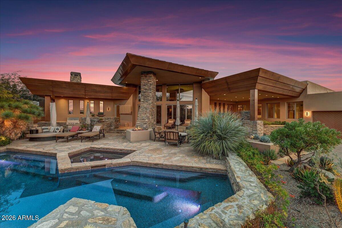 Golf Membership Available! Southwest contemporary luxury meets desert elegance in this exceptional Desert Mountain estate, perfectly positioned for privacy, quietness, and views on the 10th fairway of the Renegade Golf Course. Spanning approximately 5,600 square feet, this 5-bedroom, 5.5-bath residence offers expansive, light-filled spaces designed for both grand entertaining and refined everyday living. Each oversized bedroom features an en-suite bath, while the open floor plan showcases soaring ceilings, dramatic stone, copper-trimmed low voltage lighting, and a seamless indoor-outdoor flow. The chef's kitchen anchors the home with premium appliances and generous prep space, complemented by a large, well equipped wet bar ideal for hosting. Retreat to the luxurious primary suite with a s spa-inspired bath, featuring a massive steam shower and jetted soaking tub. Outdoors, the resort-style front-back design impresses with a negative-edge pool, spa, built-in BBQ, and serene desert and mountain views. A true entertainer's delight, with over $300,000 in recent upgrades including solar, this one of a kind home embodies the finest of Desert Mountain and North Scottsdale living.