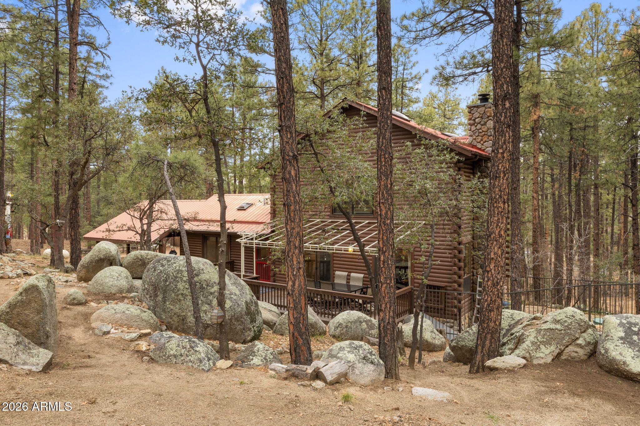 Tucked among the pines on a beautifully private 0.9- acre lot, this charming Prescott cabin offers the perfect blend of warmth, character, and outdoor living.  Backing to open Prescott National Forest land, the home features 3 bedrooms, 2 bathrooms, inviting living spaces, and multiple decks designed to take in the peaceful forest setting, dramatic boulders, and fresh mountain air.  Whether you are relaxing by the fire, entertaining outdoors, or enjoying the dog run and bocce court,  this property captures the best of cabin living with space, privacy, and true connection to nature.  Check documents for Upgrades and list of furniture for sale on separate bill.