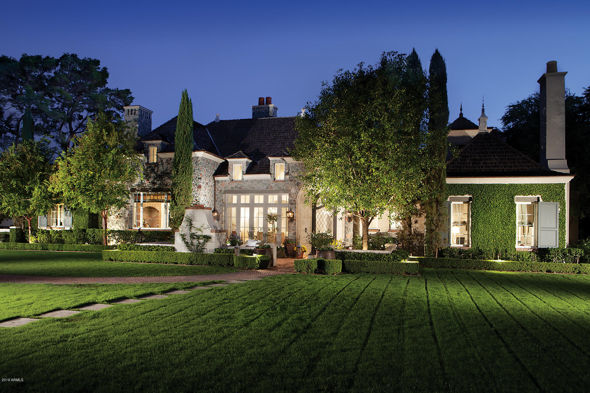 This stunning French inspired home located in the heart of Arcadia with its own private gate is a must see. Meticulous designed by Mathew Thomas and built by Nance Construction. So many special features to mention from the reclaimed brick in the kitchen to the hand trawled plaster walls throughout this home it is exuding with detail. The soaring ceilings, windows and sliding doors flood the house with warmth and natural light. The front patio is charmed with outdoor fireplace visible from the dining room with french doors. The open floor plan boasts a total of 5 bedrooms, 7 bathrooms, including the guest house, an office and a full workout room. The master is a true retreat with gorgeous windows overlooking lush yard and  bathroom with marble flooring, floating tub, oversized shower and expansive his and her closets. The 4 car garage offers plenty of storage and is equipped with a full kitchen and is fully air conditioned. Flowering gardens, trees, vines, trickling water features  and loads of architectural detail create the finishes of this timeless estate. Located off of Exeter you are close to Old Town shopping, restaurants, and Fashion Square. More photos are coming soon.