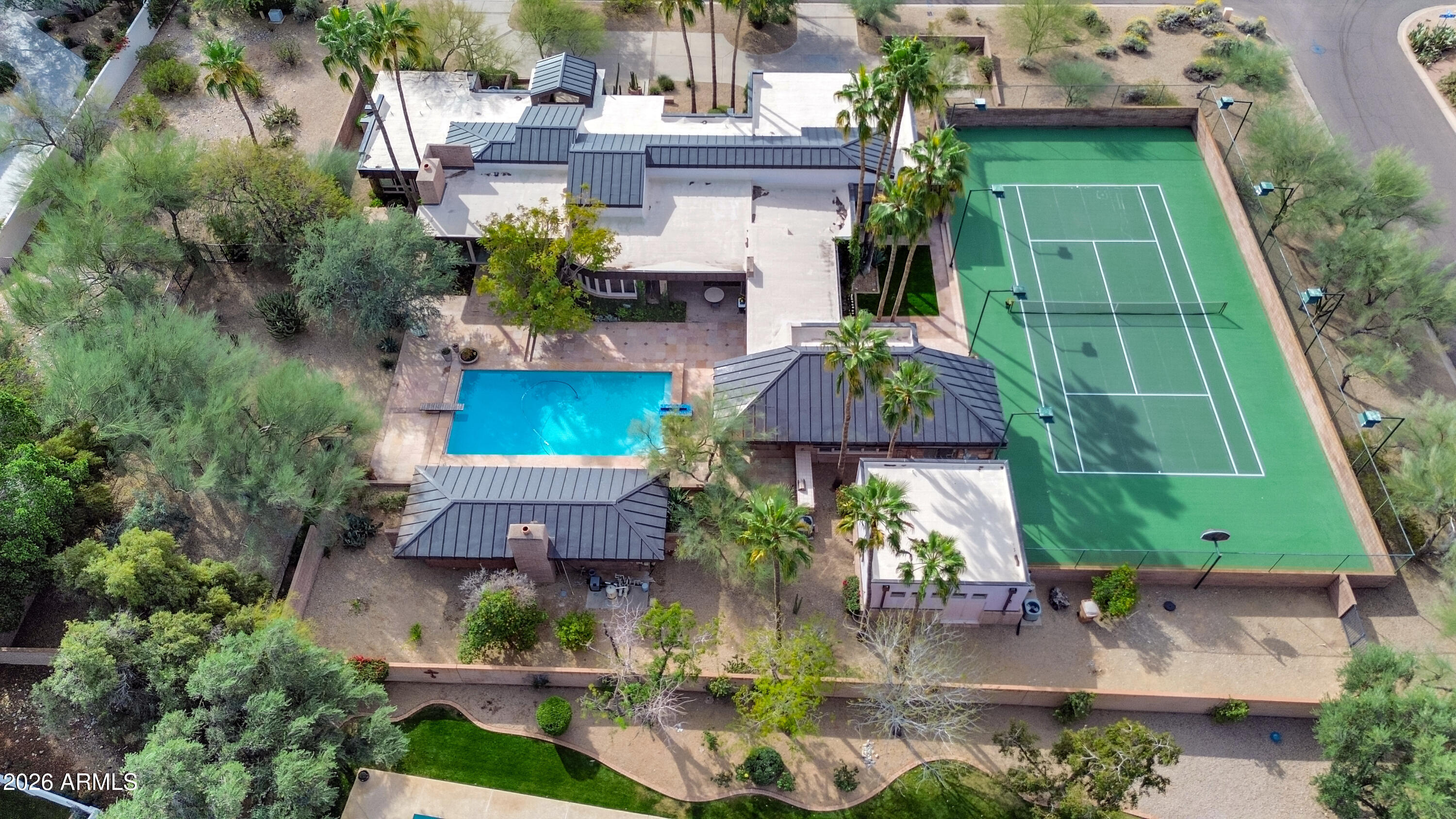 A rare find in Paradise Valley, this exceptional architectural gem is defined by clean contemporary lines, gorgeous wood ceilings, and windows galore that fill the home with natural light. Custom built by the original owners and meticulously maintained, the property offers a remarkable blend of character, privacy, and tranquility. The main residence features 3 bedrooms plus an office, while the detached guest house includes a bedroom, sitting area, and full bath, creating an ideal space for guests, extended family, or multigenerational living. A separate workshop/casita adds versatility, while the serene grounds are enhanced by a tennis court and lots of covered space with fireplace - making it ideal for outdoor entertaining. The home features a distinctive metal roof that beautifully complements the architecture. All improvements to the house have been made by GM Hunt. The property is ideally located to hiking, grocery, restaurants, shopping and easy access to downtown and airport.