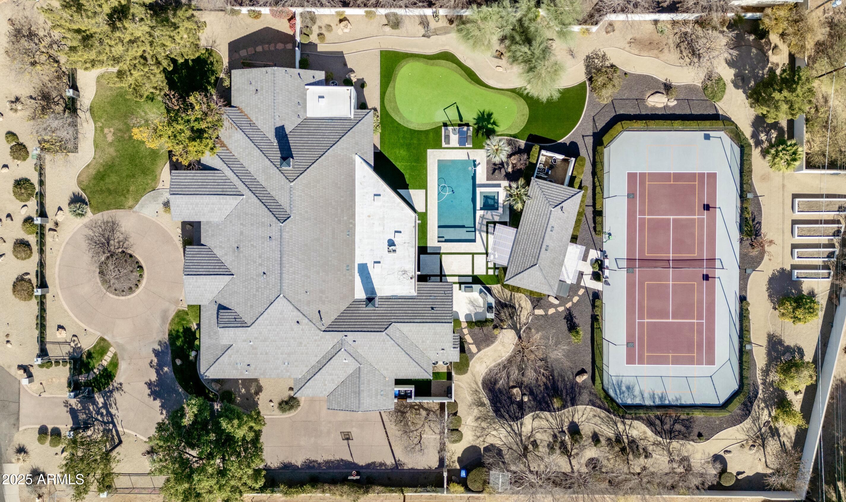 Located in the prestigious Biltmore area of Phoenix, this exquisite GATED luxury home sits on OVER 1 ACRE.  This estate offers a seamless blend of elegance, recreation, & wellness that features a private tennis court, pickleball, DETACHED Guest House, pool, spa, putting green, outdoor BBQ area & pizza oven.  The main home is 5 beds/5.5 baths PLUS office, workout room, sauna, & large kid's playroom/study.  Showcasing sophisticated craftsmanship with spacious living areas, soaring ceilings, & ideal floorplan for entertaining.  The gourmet kitchen is a chef's dream with top-of-the-line Sub Zero & Dacor appliances, and huge island.  Walkable access to upscale shopping & dining.  It's more than just a home, it's a true retreat where luxury & wellness come together in perfect balance.