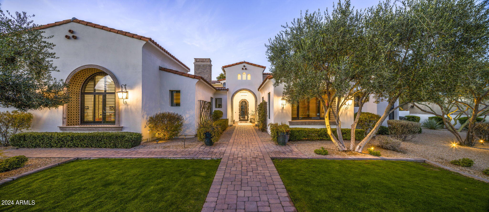 This luxurious residence nestled in the heart of Paradise Valley offers stunning vistas of Mummy Mountain. Upon entry, be greeted by gleaming wooden floors, soaring ceilings adorned with rustic wood beams, and sweeping panoramic windows. The chef's kitchen boasts dual islands, top-of-the-line Wolf/Sub-Zero appliances, and opulent golden accents. Entertain in style in the spacious living room, complete with a generous bar, wine room, and expansive floor-to-ceiling doors leading to the lush backyard oasis. A recent addition includes a state-of-the-art movie theatre with a wet bar, wine fridge, plush seating, and a large screen with a built-in projector. Outside, the sprawling backyard beckons with a putting green, heated pool and spa, ramada, fire pit, and a built-in barbecue area with all the essentials. Additional features include a five-car oversized garage, limestone fireplaces, marble countertops, and countless other luxurious touches. Experience the epitome of luxury living firsthand, schedule your viewing today!