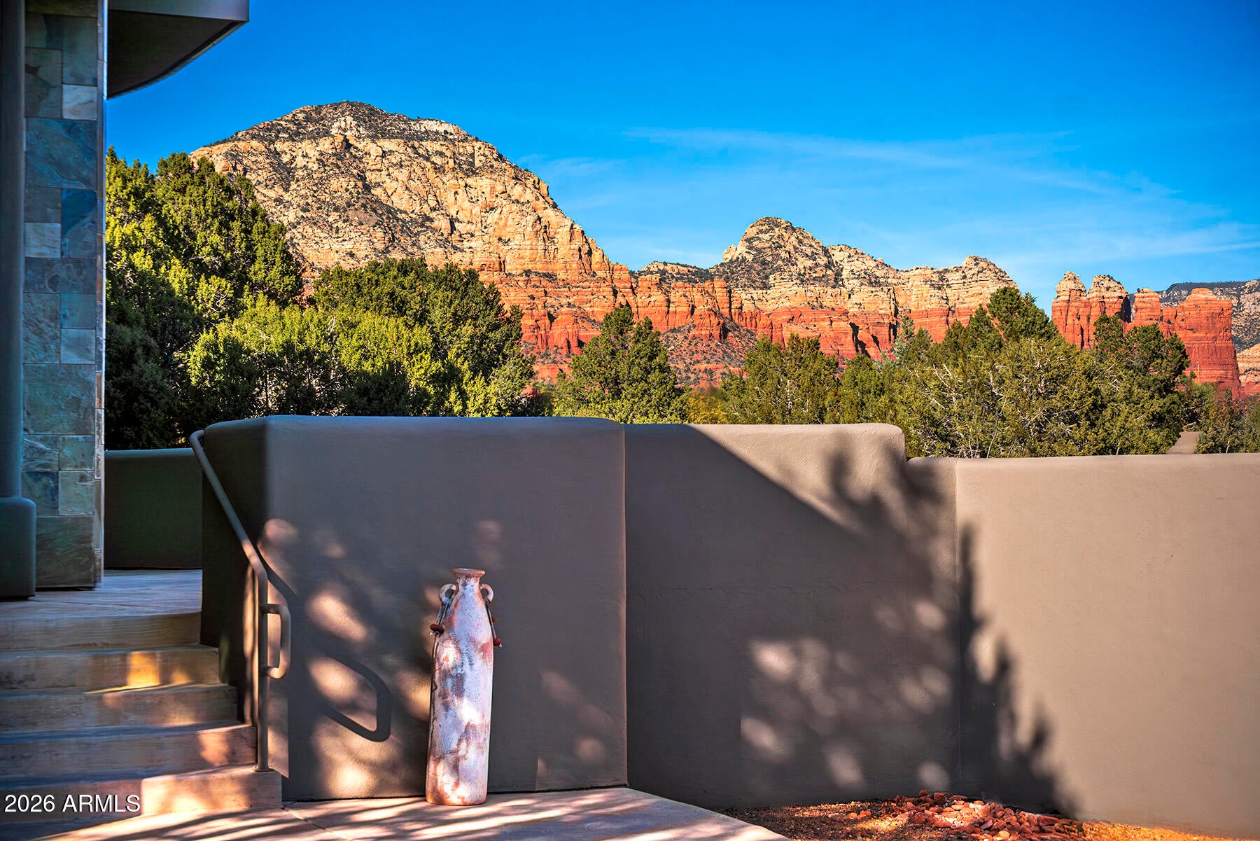 Wright-Inspired Sanctuary with Private Access to Trails & Red Rock Views!

Experience the perfect harmony of architecture and nature in this Frank Lloyd Wright-inspired home. Set on a secluded .8-acre lot in West Sedona, soaring windows frame inspiring Red Rock. The split floor plan features a sophisticated office with custom built-ins and three cozy fireplaces, including a dramatic double-sided fireplace that opens to an expansive view patio. Complete with a private neighborhood gate to world-class hiking, an immense 2.5-car garage for all your adventure gear, and no HOA, this home is the pinnacle of West Sedona indoor-outdoor living.
