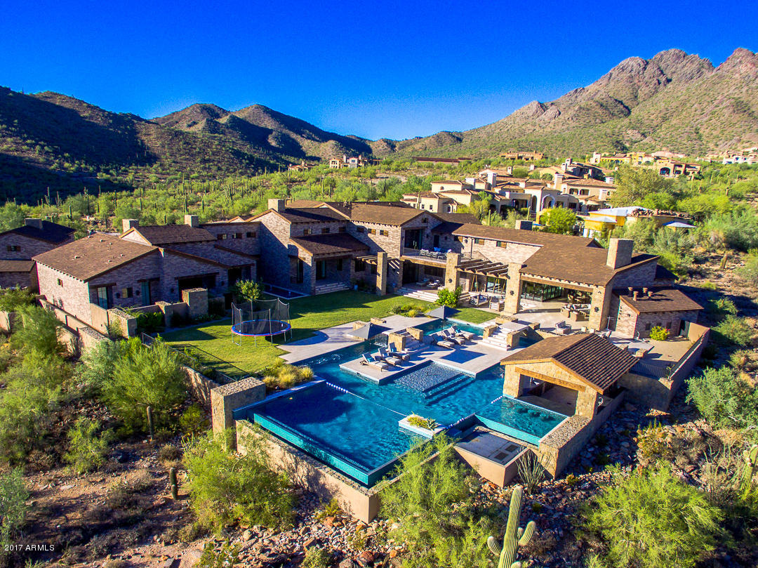 Nestled in the upper canyon of Silverleaf, this one of a kind custom home was designed and built for the lifestyle you deserve! From the moment you pull up to the privately gated motor court you will be totally impressed! The interior is spacious, comfortable, casual, yet elegant. The floor plan was designed for entertaining. The main house features a main level master suite plus 4 additional en-suite bedrooms, private office, exercise room, and home theatre. The automated pocket doors brings in the outdoor living space. Enjoy the lazy river, pool cabana,  and swim up bar while watching amazing sunsets, city lights, and views directly down the runway of the Scottsdale Airpark. Built by John Schultz Development and custom crafted by Kristin Hazen Design.  What memories will you make?