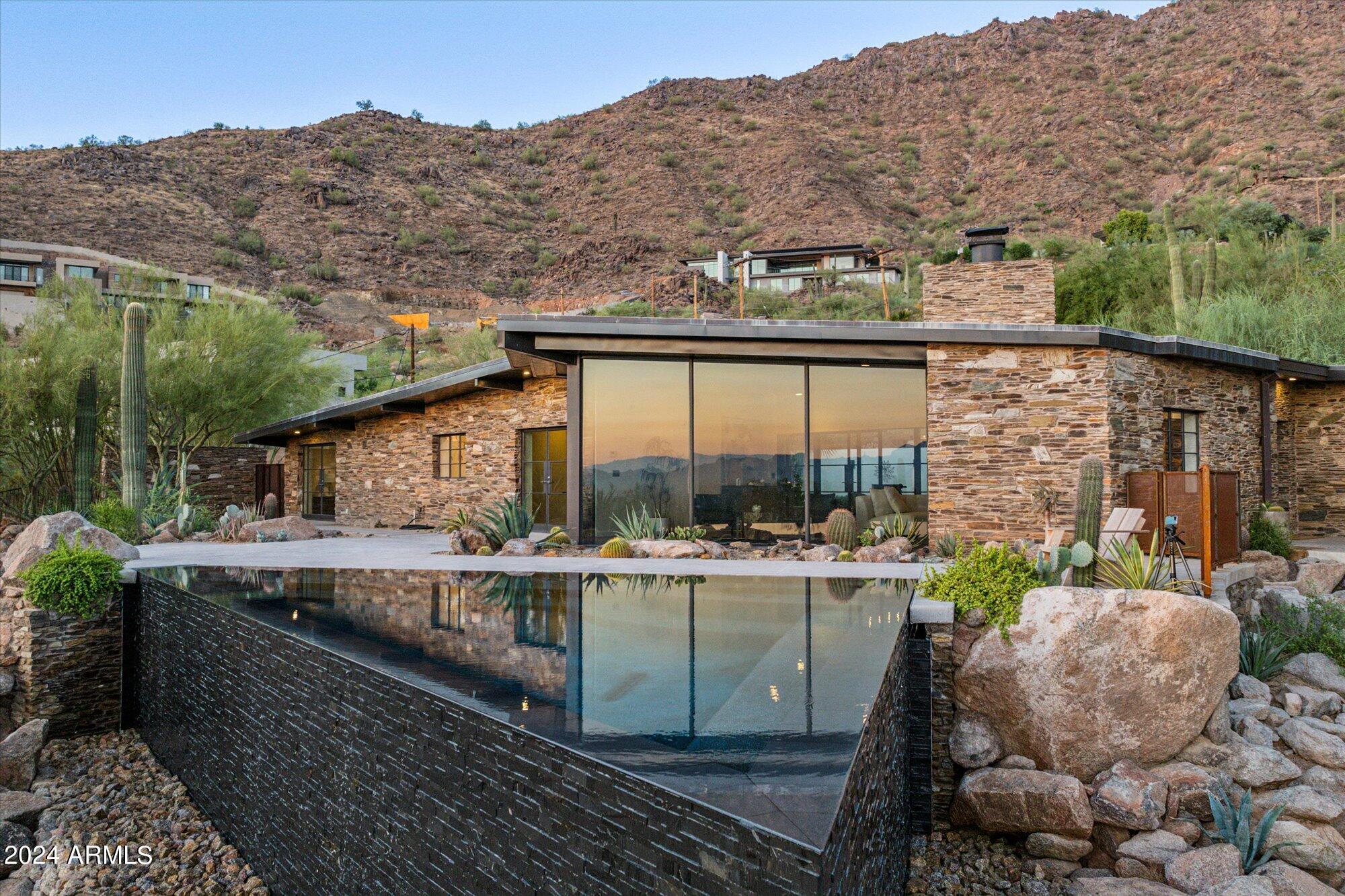 This Mid-Century Modern is truly a one of kind work of art situated on Camelback Mountain. Escape into the peace and tranquility of a home built to be a part of the Mountain with your own personal botanical garden and views from Camelback to Four Peaks. Awake each morning to spectacular sunrises and watch the desert come alive every day. In the evening retreat into your private backyard looking up at Camelback Mountain. This jewel box was built to optimize the views from every room and create a true retreat in the heart of Paradise Valley. Walk to world class resorts, restaurants, hike on the Cholla Trail, or relax into your spa and take in the views. This understated luxury home embodies what it is to live on the Iconic Camelback in the Arizona desert
