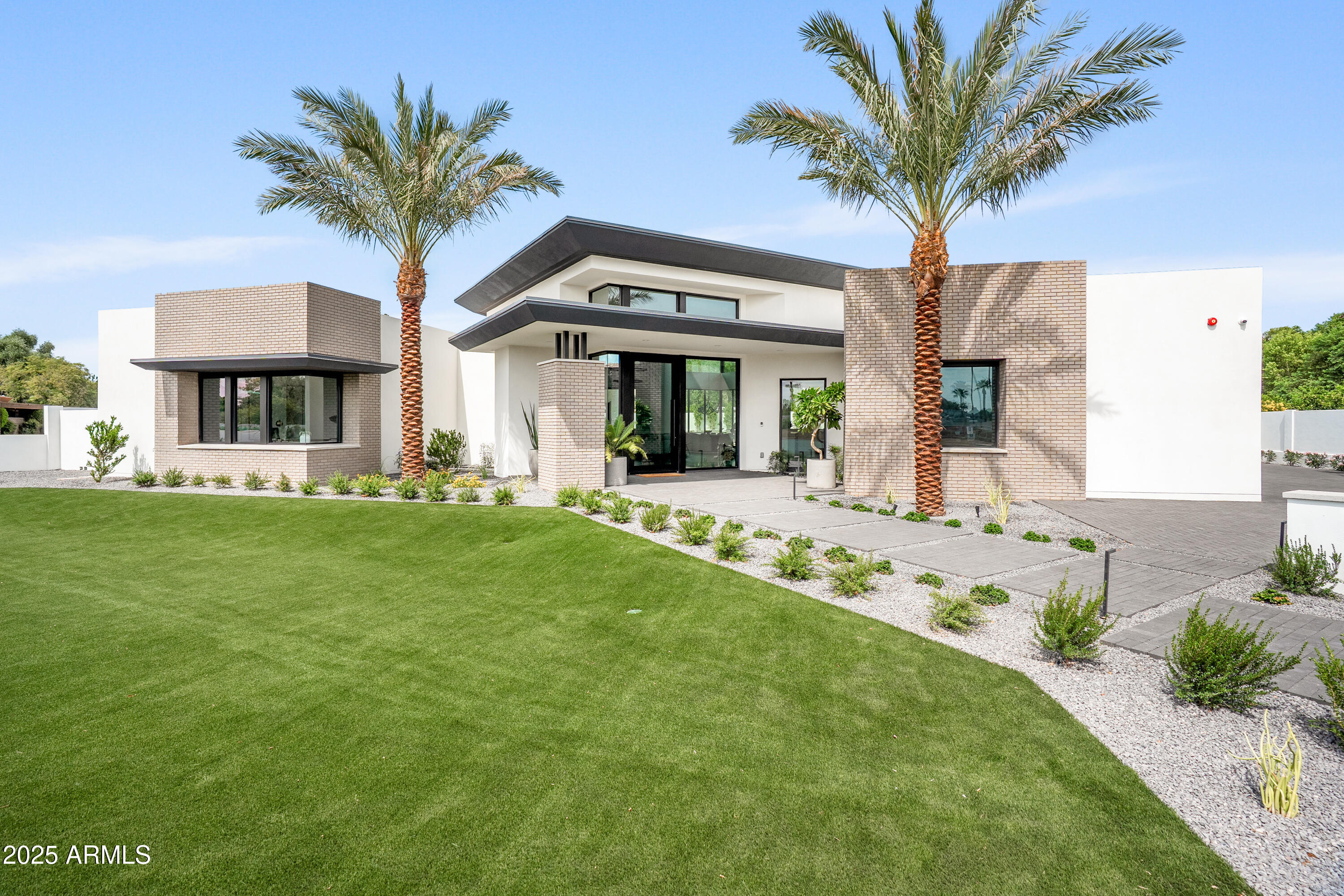 Now available in the heart of Arcadia! This brand-new modern luxury estate by Encanta Homes is a rare opportunity and one of only a few new builds currently available in the neighborhood. Blending elegance with everyday comfort, the home captures warm modern design with iconic Camelback Mountain views as its backdrop. The split floor plan centers around a dramatic Gallery Great Room showcasing a dolomite fireplace wall with custom wood-slat surround, an 85'' Samsung Frame TV, and a temperature-controlled 280-bottle wine display. A separate rec room with wet bar expands the living space, while a disappearing corner wall of glass creates a seamless indoor-outdoor connection. The chef's kitchen stands as the true centerpiece, featuring a 60'' Wolf range, Sub-Zero refrigerator and freezer, additional sink and dishwasher, and expansive storage. The primary retreat offers a private escape with a fireplace, coffee bar, spa-like bath, and dual custom closets.

Outdoor living is equally refined with a covered patio, Wolf BBQ and sink, linear fire pit, and a custom pool and spa with automatic cover. Low-maintenance turf, modern landscaping, and extensive hardscape with accent lighting complete the striking curb appeal. This is more than a new home, it's a one-of-a-kind architectural achievement by one of Arcadia's premier builders, perfectly situated on one of the area's most desirable streets.
