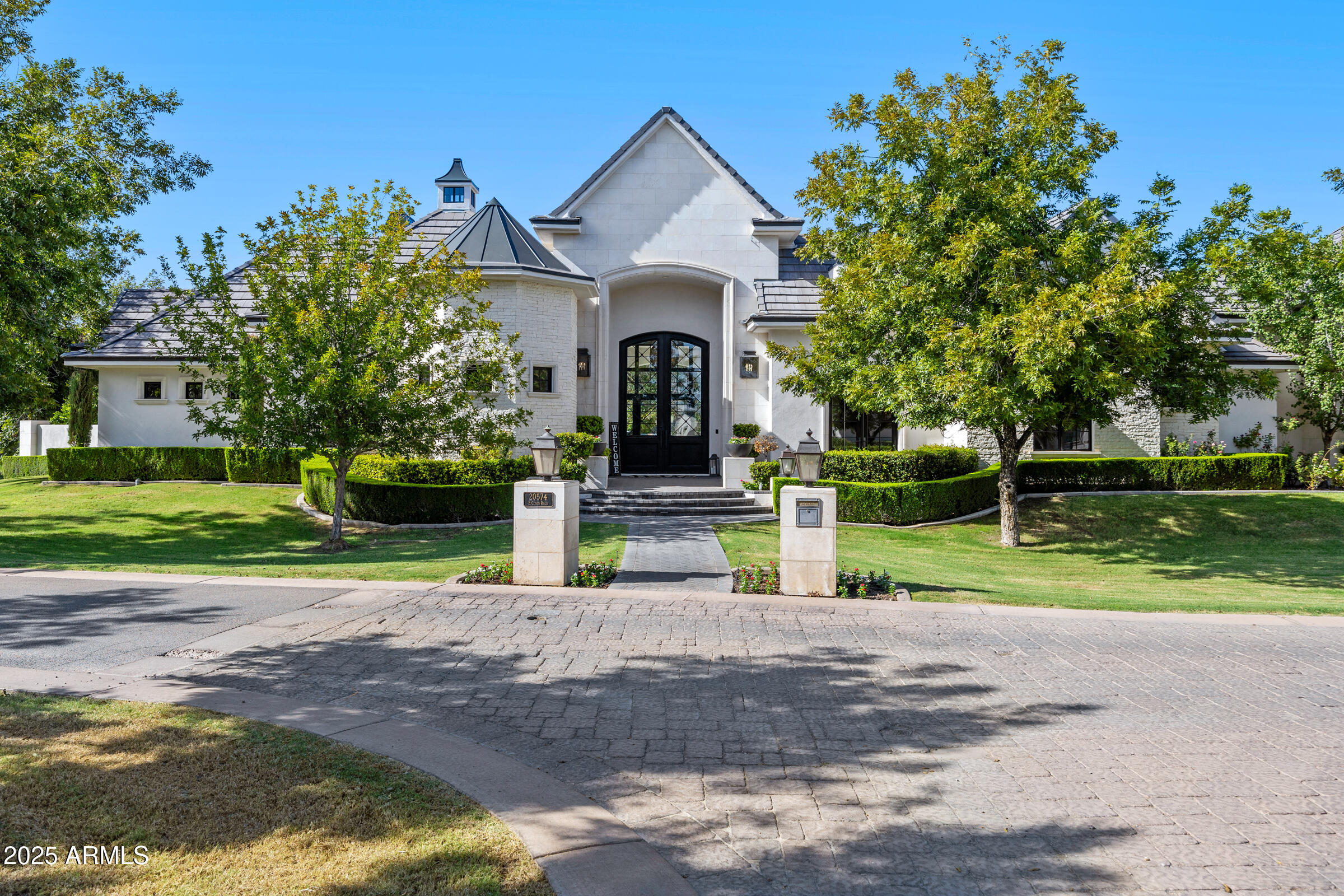 Welcome to 20574 E Cloud Rd, an extraordinary custom estate located in the prestigious gated community of The Pecans in Queen Creek. Perfectly positioned on over 1.3 acres of tree-lined grounds, this 2018-built home offers 6,476 square feet of single-level living with a seamless blend of timeless architecture, modern amenities, and total privacy. From the moment you arrive, the grand entry and manicured landscaping set the stage for sophistication. Inside, soaring ceilings with coffered detailing, expansive windows, and wide-plank wood floors create a bright and inviting atmosphere. The chef's kitchen is the centerpiece of the home, designed with dual islands, marble counters, custom cabinetry, and a butler's pantry, making it ideal for both everyday living and large-scale entertaining.

This home features five spacious bedrooms and five and a half bathrooms, along with multiple living areas including a great room with a fireplace, custom built-ins, and walls of windows that open to the backyard. The owner's retreat is a private sanctuary complete with a fireplace, spa-like bathroom with dual vanities, a freestanding soaking tub, oversized glass shower, and a custom walk-in closet featuring dual chandeliers and abundant storage. Additional highlights include a designer powder room, a spacious laundry room with workstations and cabinetry, and a 4-car garage.

The backyard is a true resort setting, framed by mature pecan trees and privacy hedges, featuring a sparkling pool and spa with multiple covered patios for year-round enjoyment. This rare estate offers the perfect balance of luxury, privacy, and convenience, just minutes from top-rated schools, fine dining, golf, and all of Queen Creek's best amenities.