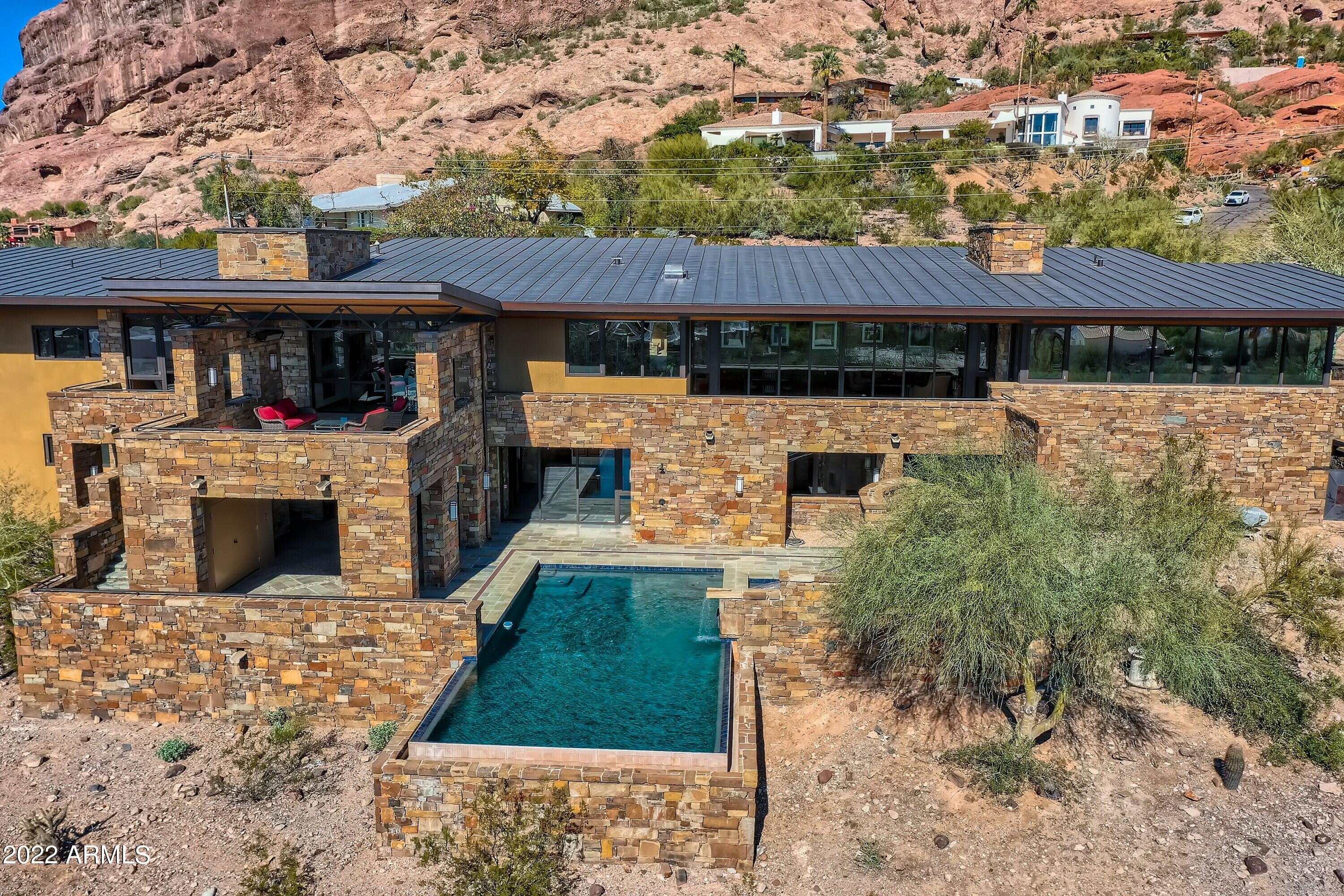This soft contemporary home on the south slope of Camelback Mountain, with panoramic city and mountain views, was custom built for family and
 entertaining!  Window walls in the great room, family room and recreation room slide open and disappear, offering true indoor/outdoor living. The large flagstone entertaining decks and porches have radiant heaters for winter and
 misters for summer, perfect for enjoying the beautiful Arizona sunsets any time of year.  A Chefs Gourmet Dream Kitchen and butlers pantry awaits, equipped for preparing meals to host large gatherings or simply to make a
 family dinner!  Plenty of pull-out storage drawers for your dinnerware, serving
ware and cookware reside within the distinctive wood cabinetry. A large private executive office is located just off the front door with a breathtaking view of Camelback Mountain as its backdrop; its location provides easy access for business partners or clients to visit. The main house offers five ensuite bedrooms. The primary bedroom wing has an enormous walk-in closet. The four remaining bedrooms are on the lower level of the home. Bedroom #5 was used as a dance room/gym with resilient flooring, ballet barre and a mirrored wall. A 500 square foot casita (bedroom #6) located off the putting green and courtyard, offers privacy for your guests as well as amazing views of both Camelback and Camelhead. The lower level has 9-foot ceilings and plenty of natural light to enjoy billiards, foosball and video games in the recreation room. A kitchenette, a changing room for guests using the outdoor play pool with slide, a media room/homework room, library, and other flex spaces are available to meet your family needs. An oversized four car garage easily stores all of your family's sporting equipment.  Picture yourself in this spectacular home, filled with captivating spaces and incredible views that encourage both entertaining and family gatherings. It's all yours in this much coveted hillside neighborhood of east Phoenix.