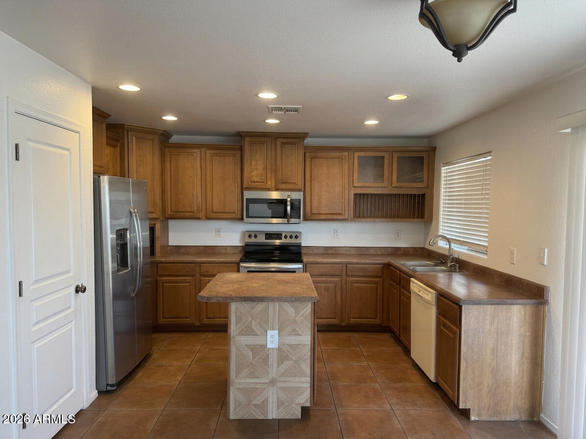 Large lot • Loft + 4 bedrooms
Two-story home, 2.5 baths, and a loft offering flexible living space. Open kitchen with center island, pantry, wood cabinetry, and stainless steel appliances flows into the main living area. Great room includes built-in media niches and fireplace. Tile flooring in kitchen and main areas with carpet in living spaces and bedrooms. Primary suite includes dual sinks and walk-in closet. Interior presents opportunity for cosmetic updates including paint and flooring. Block-fenced backyard with space for outdoor use,. 2-car garage and tile roof. Located near Ironwood Rd and Ocotillo Rd corridor with access to grocery, dining, and services. Approximately 0.3 mi to Jack Harmon Elementary, 1.4 mi toJ.O. Combs Middle School, and 2.9 mi to Combs High School