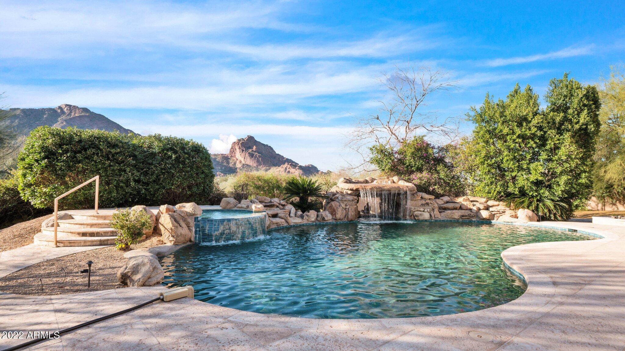 Majestic Camelback views await from this timeless Mediterranean nestled in the true heart of Paradise Valley.  Privately gated and surrounded by mature landscaping this exquisite estate has been home to only one family.  You will be enchanted as you welcome yourself into the private courtyard with a tranquil fountain that leads you into the front foyer. The soaring ceilings and glass sliders perfectly frame the sparkling pool, grotto and the entire length of Camelback Mountain in the distance.  The kitchen is both spacious and elegant featuring all of the amenities needed to entertain. The space opens to the family room with a custom circular indoor/outdoor bar that seems to bring the outdoors in- for true Arizona style living. Escape to the luxurious master retreat with picturesque views, cozy fire -places and a spacious spa like bath all creating a feeling of relaxation and ultimate privacy. Meticulously maintained with spacious bedrooms, executive office, theatre, flex space, and a custom wine cellar that offer endless options for entertaining family and friends.  The backyard is a true paradise with covered patio space, built in BBQ, retractable awnings and a resort style pool & spa with a cascading waterfall and grotto. Just imagine, this striking atmosphere all illuminated by the setting sun and star filled desert sky