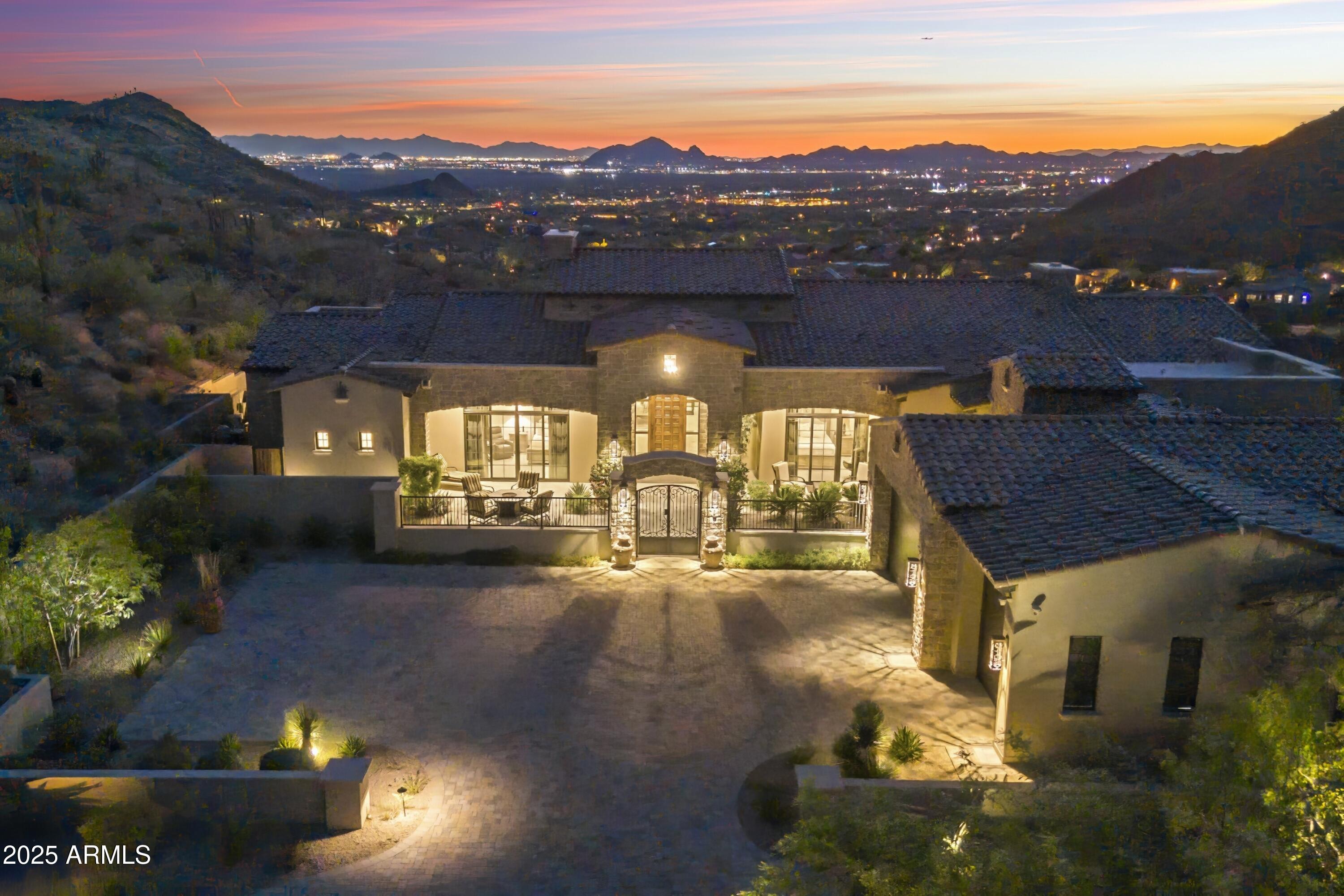 Perched atop a hill with panoramic views of Camelback Mountain and the Valley below, this gem was born from a single moment of awe—when the original owners stood on the land and said, ''WOW, what views we could have!'' They transformed the terrain to create a completely flat property, resulting in a home with zero steps and seamless flow throughout. ✨ Interior Design by James McIntyre creates a harmonious blend of elegance and comfort. •Wall artistry by Anna Sadler of Surface Refinements. See her revered wall treatments in the entry, hallway, and dining ceiling evoke a sense of wonder and sophistication. •Feel the indoor tranquility of wrought iron accents, exposed wood beams, expansive glass walls that frame breathtaking views. 🚗 An 8-car garage with the lifts. Elevate your lifestyle with the Savant Smart Home System. Control lighting, climate, sound, video, security, misters, heaters, and firepits all from your phone.  Custom cabinetry thoughtfully integrated throughout the home. Chef's kitchen has six-burner gas range and high-end appliances for culinary excellence.
"Negative edge pool is up to 8 feet deep, merging visually with the horizon. Each bedroom is a private retreat. Five ensuite bedrooms, each with their own outdoor access. The primary suite's glass patio wall floods the room with natural light and opens to a private patio with serene views.  Enjoy outdoor elegance, sunset serenity. Every evening becomes a moment of peace and reflection.