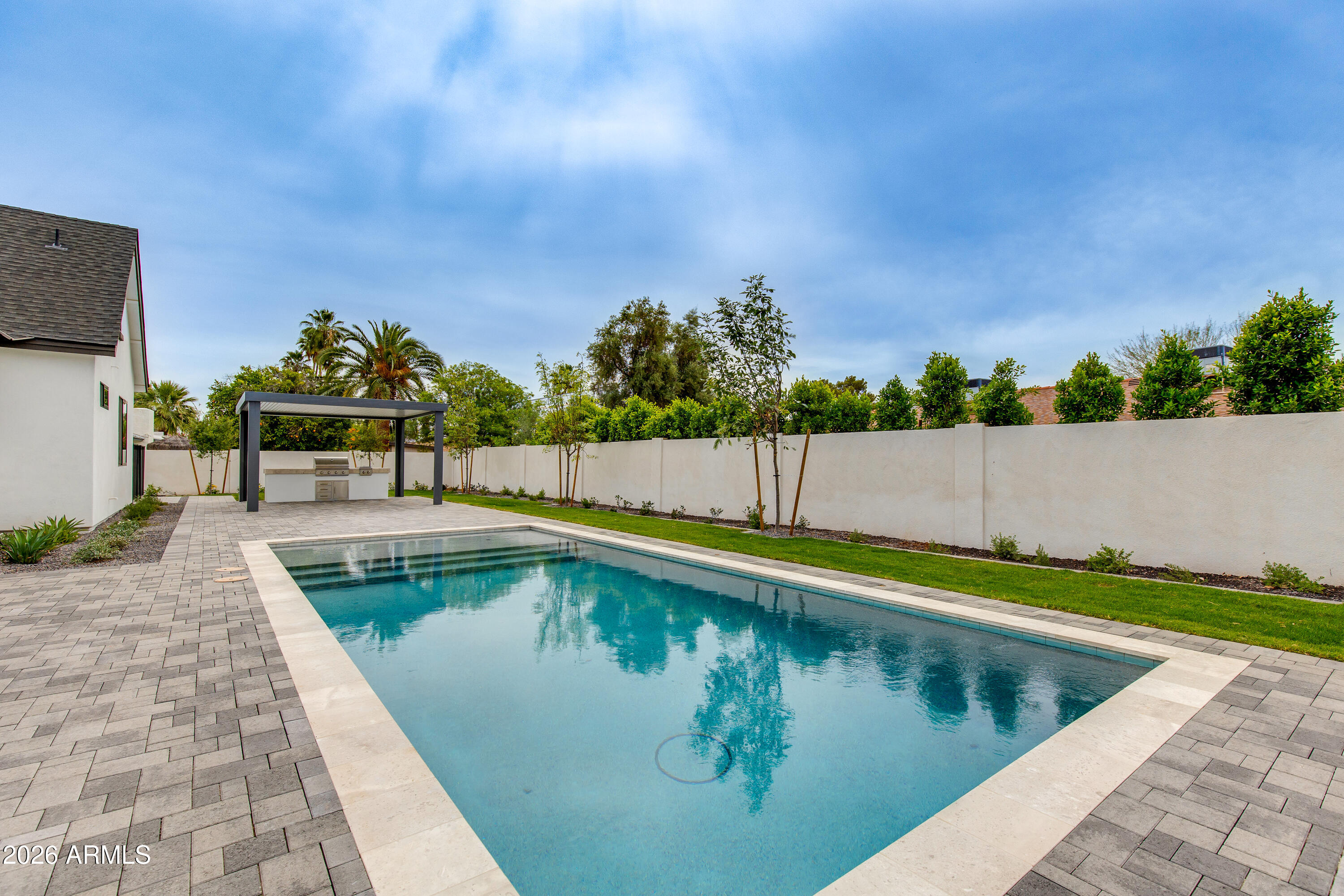 Brand-new Thomas James Home showcasing dramatic ceilings, refined architectural detail, and exceptional craftsmanship throughout. This sophisticated residence offers a light-filled, open-concept layout complemented by curated designer finishes and timeless elegance. High-end materials, elevated design elements, and seamless indoor-outdoor flow create a luxurious yet inviting living experience. The resort-style backyard features a stunning pool and a thoughtfully designed outdoor kitchen--ideal for entertaining. Ideally located in Scottsdale's coveted 85254 zip code, just minutes from premier shopping, dining, and lifestyle amenities, this new construction home presents a rare opportunity to own quality, style, and distinction in an established neighborhood.