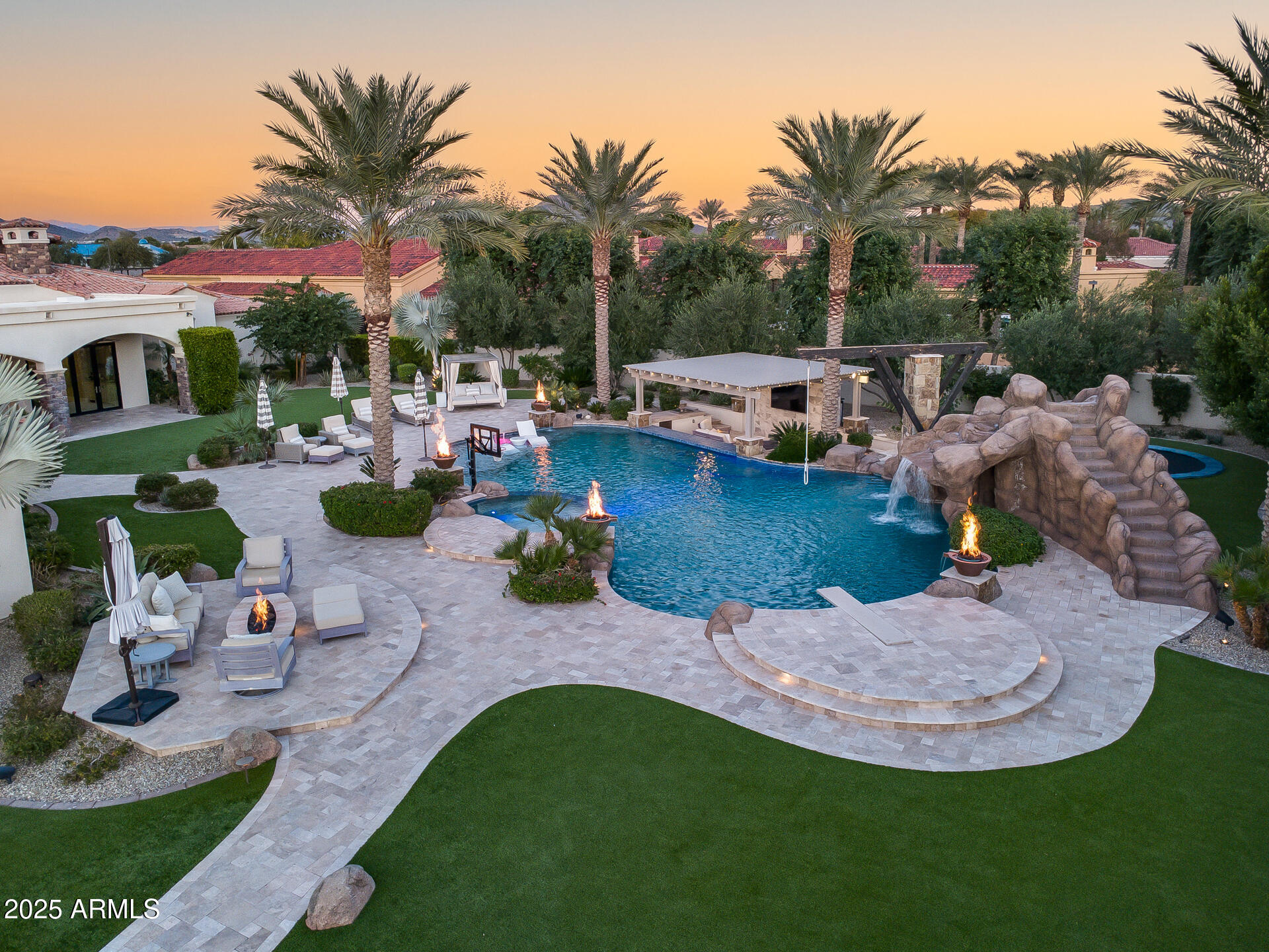 The Crown Jewel of North Peoria

A rare fusion of architectural mastery and refined livability, this gated custom estate sits on over an acre within one of North Peoria's most exclusive enclaves. With grand hallways, arched passages, and barrel ceilings adorned with hand-set brick, the home's design evokes timeless elegance from the very first steps inside. 

Crafted with the highest level of construction quality; solid alder doors, sand-cast tile roof, and a comprehensive fire-sprinkler system, the residence offers peace of mind alongside beauty.

The interior features natural stone flooring, new premium carpets, wood-beam ceilings, and a statement fireplace of marble and carved wood. Functional luxury abounds with a 700-bottle climate-controlled wine room, Lutron lighting, in-ceiling speakers, HD security cameras, and smart home control powered by RTI. 

A gourmet kitchen anchors the heart of the home, blending Sub-Zero, Wolf, and Asko appliances with artful design elements like the decorative brick oven surround and genuine quartz stone surfaces. A full butler's pantry offers additional Wolf appliances, Sub-Zero ice maker, and ample prep spaceideal for catering or entertaining at scale. 

The primary suite is a private retreat featuring dual spa baths, marble steam shower, freestanding tub overlooking the pool, boutique-level closets, private office, and plumbed coffee station with beverage bar.  

A second wing offers a dedicated flex room surrounded by three ensuite bedrooms, each offering comfort and privacy. A professional 12-seat theater with padded acoustic walls and staggered seating delivers a true cinematic experience. 

Completing the estate is a luxurious 1,200 sq ft casita with its own fireplace, laundry, and walk-in closet. 

Outside, the grounds transform into a resort with an expansive covered patio, Wolf outdoor kitchen, pickleball court, in-ground trampoline, and a heated diving pool and spa with waterfalls, grotto, and rope swingall framed by meticulous landscaping and LED lighting. 

This is a residence built for those who value craftsmanship, scale, privacy, and an elevated lifestyle. A legacy estate in every sense.