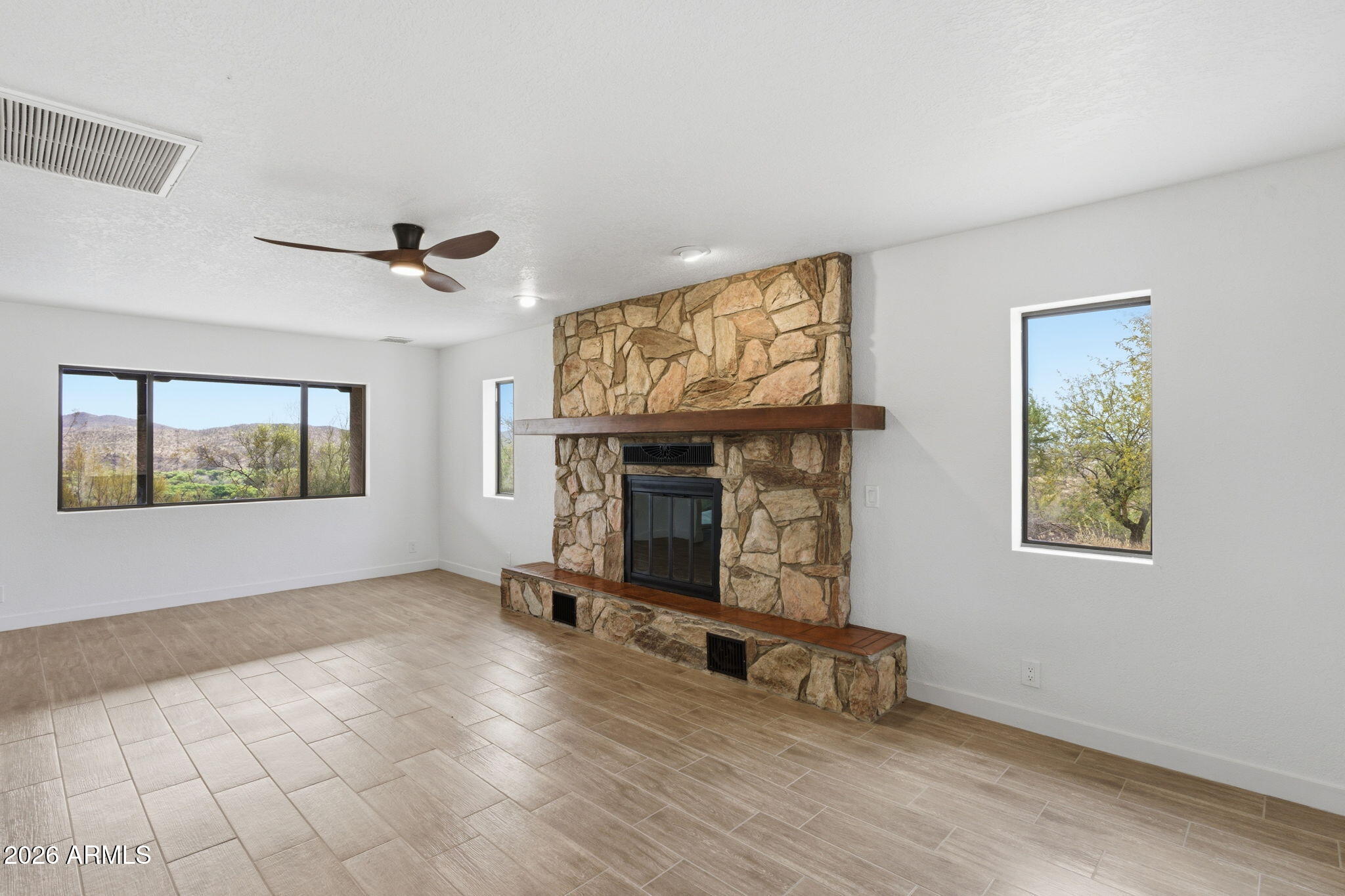 Experience the charm of open desert living in this move in ready, 3 bed, 2 bath home on 5 sprawling acres. An enclosed front patio welcomes you in, while fresh interior & exterior paint and new wood-look tile flooring create a clean, modern feel throughout. The living room features Stone Veneer fireplace & the updated kitchen shines w/ new cabinets, quartz countertops, tiled backsplash, & stainless steel appliances. The primary suite offers a private ensute bahtroom & walk-in closet. Step outside to a covered patio and wide open desert space ready for your vision. Complete w/ a 3 car garage.