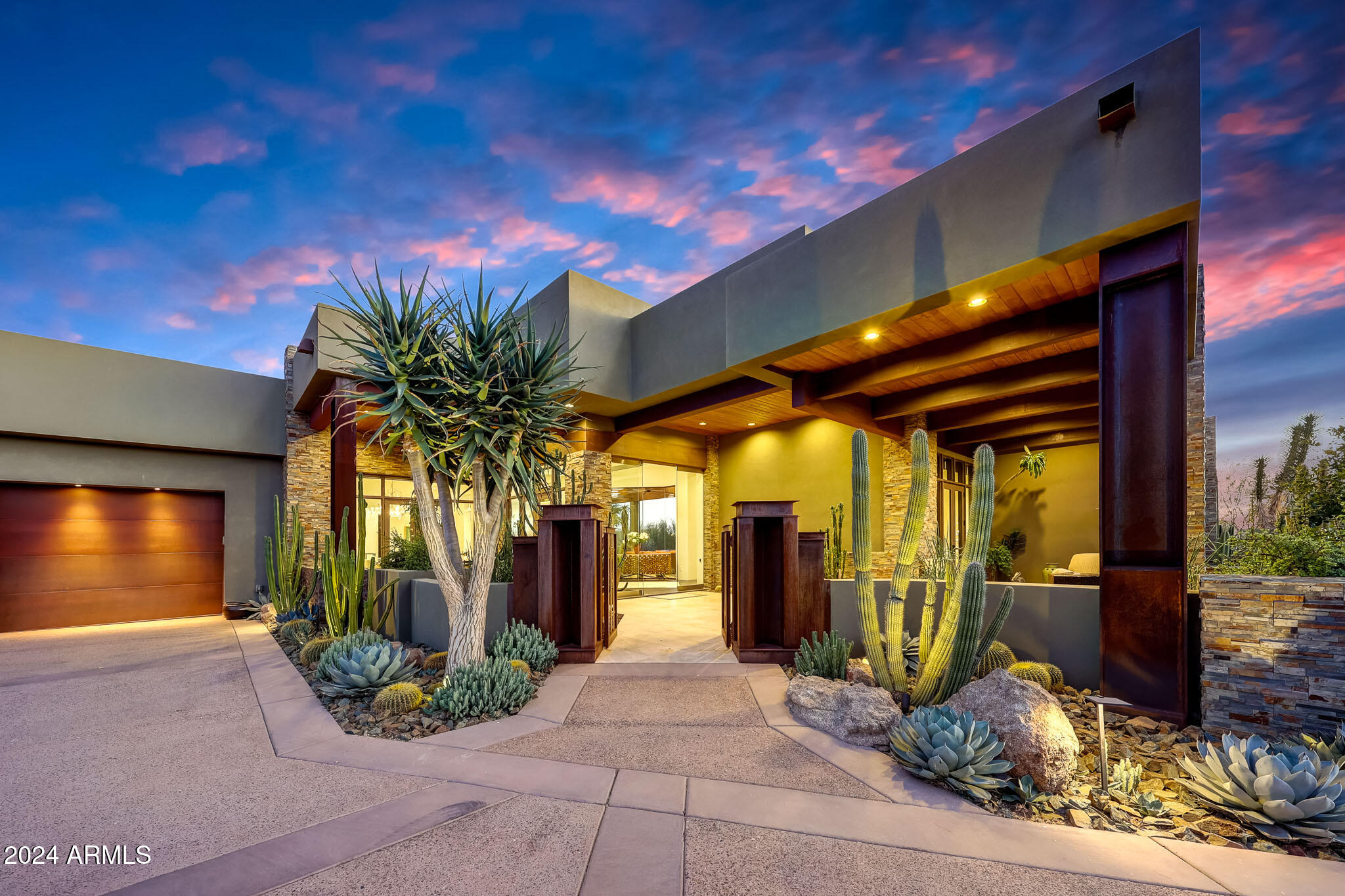 GOLF MEMBERSHIP AVAILABLE. Welcome home to this thoughtfully crafted design that intricately blends nature with living spaces and offers the finest indoor/outdoor living experience. This modern adobe home provides living on one level (no steps). The home floods with natural light with 8 pocket doors that recede fully into the wall and 6 other doors that open to the outdoor patios. The outdoor space is a showstopper that marry all the Earth's elements, uniting a large cantilevered fireplace encased in industrial steel, cool stone walls and flooring, water descents from 10 lit scuppers, and 3,200 sf of pine ceilings under roof. A steel gated courtyard with 2 Basalt water fountains and 2 Cannon Ball Rusted Steel Fire features leads to the front entry glass door.