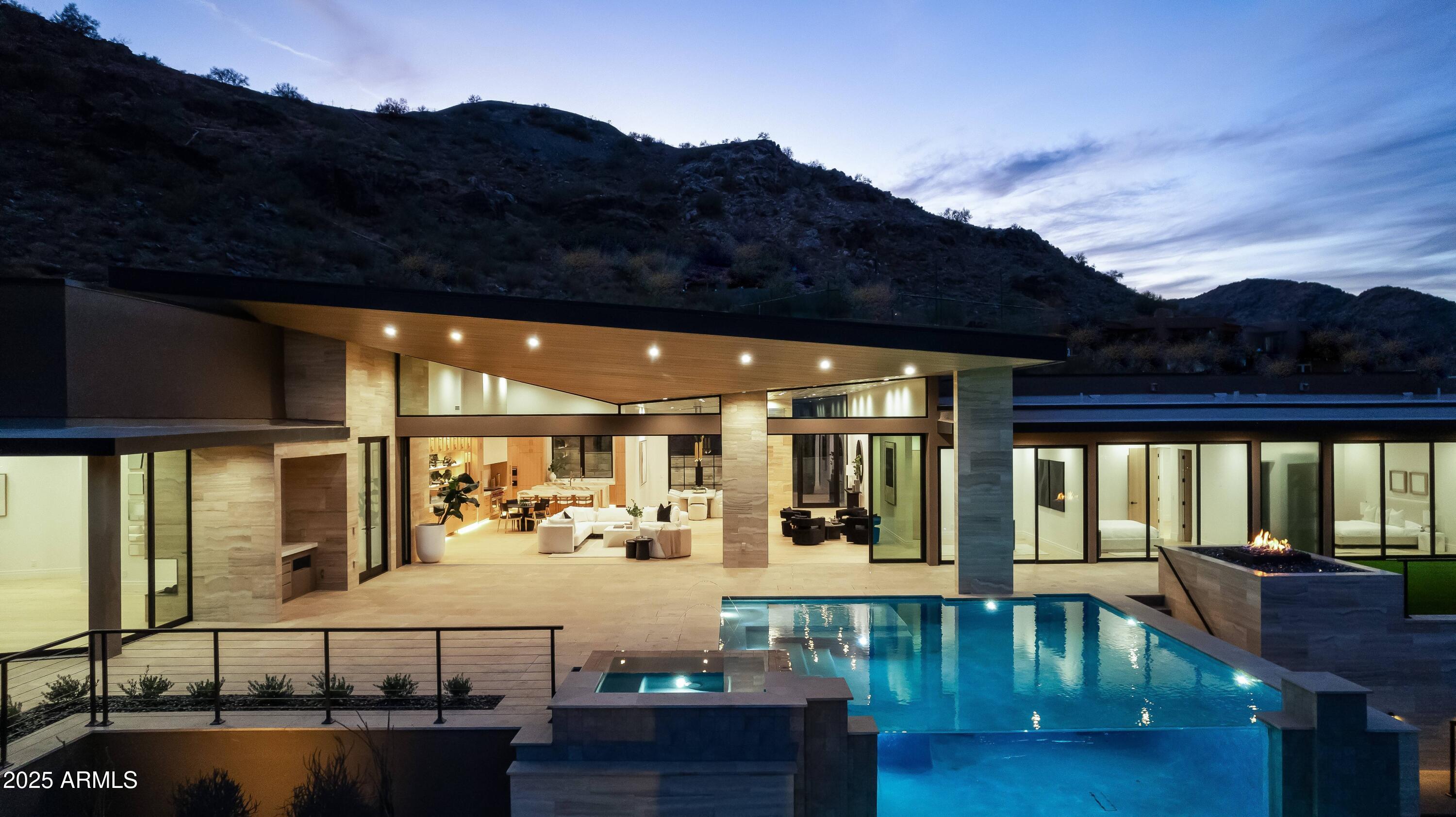 This organic contemporary, GATED estate, perched on the east slope of Mummy Mountain in Arizona's wealthiest zip code, 85253, offers epic views & amenities. The 8,312 sqft livable MAIN HOUSE with NO INTERIOR STEPS, boasts a Large Primary Suite, 2 Huge Closets, Gym, & 2 Separate Offices, The split floorpan offers 3 Additional Guest Suites, each room with Panoramic Views of North Scottsdale, Pinnacle Peak, the McDowell Mountains, 4 Peaks, Mummy Mountain, the Superstition Mountains, and City Lights.  Main spaces offer incredible natural light and over 4,000 sqft of outdoor patios, a dog run, & glass infinity edge pool, & firepit. The 1,224 GUEST HOUSE offers great flexibility with a full Kitchen and full Bathroom.  The estate boasts 7 Garages, convenient location, a perfect vacation getaway