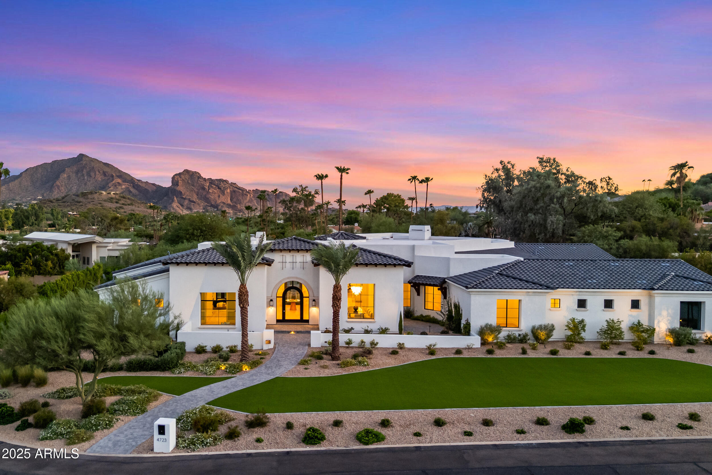 Brand-new Transitional Mediterranean estate in Paradise Valley, positioned on just shy of an acre with sweeping views of Camelback and Mummy Mountains. Designed in collaboration with a renowned builder, architect, and interior designer, this custom home blends timeless architecture with modern luxury and seamless indoor-outdoor living. The single-level floor plan offers five ensuite bedrooms, including a split primary wing for privacy, a wide-open great room with walls of glass, and multiple courtyards and patios for effortless flow. Every detail has been thoughtfully curated; from wide-plank flooring to hand-selected stone and cabinetry; creating a refined, sophisticated, and truly custom residence. The primary suite is a resort-level retreat, featuring dual closets, a steam shower, soaking tub, additional laundry, and direct access to a private patio. The chef's kitchen is appointed with professional-grade appliances, custom finishes, a walk-in pantry, and an adjacent glass-enclosed wine wall near the formal dining space. A dedicated office and a bonus/flex room provide versatile living options. The backyard is the crown jewel; designed as a private resort framed by dramatic mountain views. Highlights include an oversized negative-edge pool and spa, a built-in BBQ, a sunken fire pit lounge, a putting green, a turf play area (including pet-engineered turf), and ample space for a sport or pickleball court. Layered patios and outdoor courtyards ensure there are destinations for gatherings of every size. Additional amenities include a four-car garage with room for a lift, prewiring for EV vehicles, and a temperature-controlled workshop. Located in the heart of Paradise Valley, this estate offers privacy, luxury, and proximity to Scottsdale and PV's best resorts, golf courses, dining, and shopping. 4723 E Desert Park is more than a new build; it's a lifestyle crafted for those who want the best of desert living.