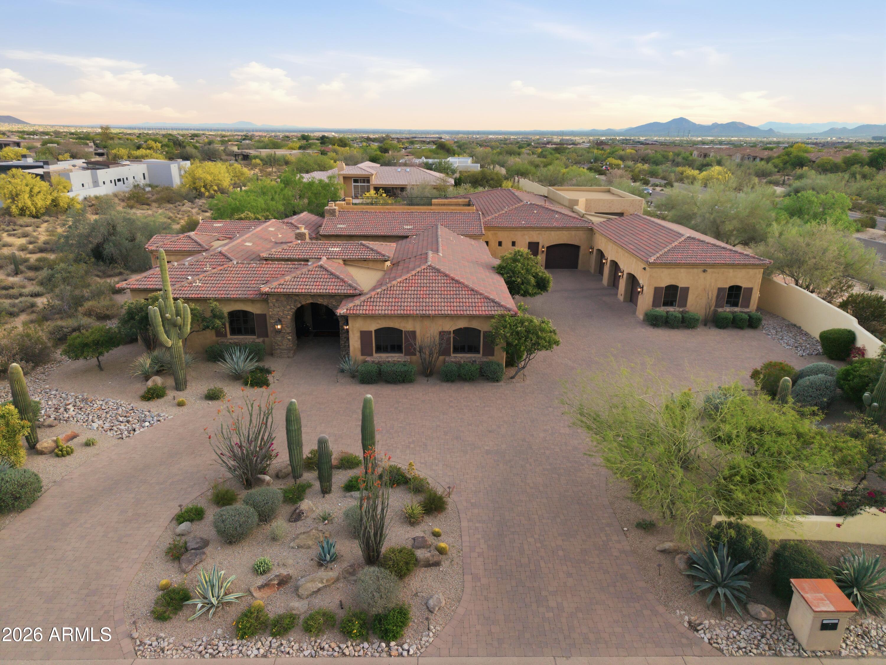 Tucked within the prestigious Pima Acres enclave of North Scottsdale, this magnificent 5,716 sq ft estate sits on a sprawling 1.3-acre lot, delivering the privacy, space, and resort-style living discerning buyers seek--all while offering unbeatable convenience to everyday amenities. Just minutes from premier shopping, grocery stores, dining, and quick access to the Loop 101, this location makes it easy to enjoy everything North Scottsdale has to offer.

The chef's kitchen is appointed with Sub-Zero and Wolf appliances, seamlessly blending professional-grade performance with timeless elegance--a true centerpiece for entertaining and everyday living alike. Open-concept living spaces flow effortlessly to the outdoors, where a resort-style pool and expansive covered patio create an unrivaled Arizona retreat. Located within the highly acclaimed Scottsdale Unified School District, including Copper Ridge School and Chaparral High School, this home offers access to some of Scottsdale's most sought-after schools.

Designed for year-round enjoyment, the expansive covered patio overlooks resort-like grounds featuring a large pool with water features and fire pots, an 8-person spa, and a built-in outdoor kitchen complete with a Wolf BBQ, fireplace, fans, ceiling heaters, and misters. Whether hosting a sunset dinner party or enjoying a peaceful morning outdoors, the lifestyle here is exceptional.

At the heart of the home, a charming outdoor courtyard offers an inviting gathering space complete with a fireplace and ambient string lighting--ideal for intimate evenings or entertaining under the stars. A dedicated game room adds even more flexibility for recreation and relaxation.

Ascend to the rooftop terrace and take in breathtaking mountain views and sparkling city lights--an unforgettable backdrop that defines elevated North Scottsdale living. The attached casita features a full living room, kitchenette, direct patio access, and ample space for private outdoor seating, creating the perfect retreat for guests or extended stays.

Car enthusiasts will appreciate the 4-car garage with high ceilings and lift potential. In addition, a bonus flex space with soaring ceilings offers incredible versatility--ideal for a golf simulator, batting cage, private gym, hobby room, additional storage, or customized lifestyle space tailored to your needs.

Located just minutes from DC Ranch Marketplace, Kierland Commons, Scottsdale Quarter, AJ's Fine Foods, Safeway, and countless restaurants and entertainment options, this home places you in the center of it all with easy access to the Loop 101, world-class golf, and Scottsdale's premier events including the WM Phoenix Open, Barrett-Jackson Scottsdale Auction, and Scottsdale Arabian Horse Show. 8801 E Sierra Pinta is more than a home--it's an exceptional lifestyle without compromise. Come experience it for yourself.