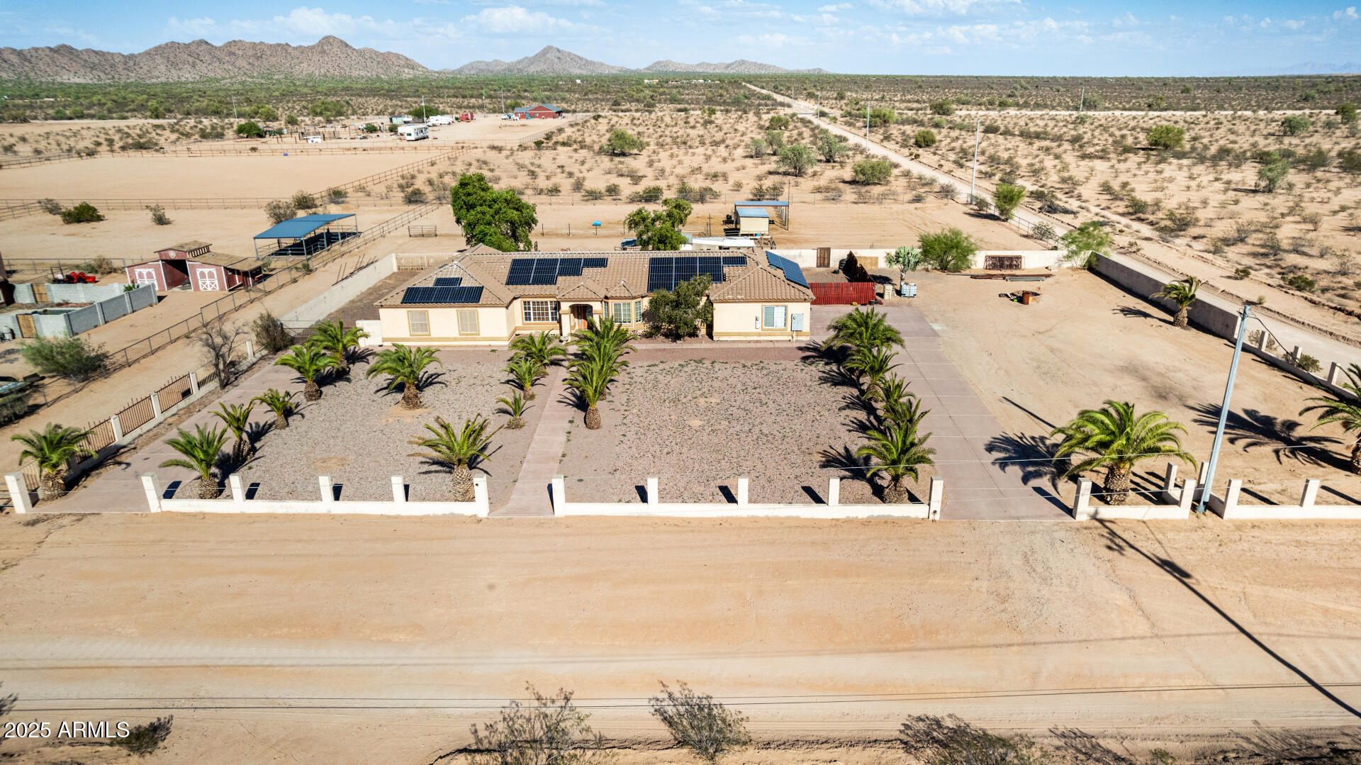 What a RARE find! Nestled on a HUGE 1.5-acre corner lot, this remarkable horse property will surely impress you. Its charm starts with a desert front yard with palm trees. The fantastic single-level home offers 5 beds & 3 baths, seamlessly blending everyday comfort and functionality. The inviting interior showcases tons of natural light, wood shutters, neutral palette, tile flooring in common areas, and soft carpet in bedrooms. You'll love the spacious open layout paired with a fireplace, French doors to the back, and vaulted ceilings that add to the airy feel. The impeccable kitchen boasts SS appliances, solid-surface counters, mosaic tile backsplash, a pantry, recessed & pendant lights, wood cabinetry w/crown molding, a 2-tier peninsula w/breakfast bar, and a bay window w/breakfast bar. The main bedroom includes a walk-in closet and an ensuite with dual sinks, soaking tub, & a tiled shower. Two secondary bedrooms share a Jack & Jill bathroom. HUGE! The backyard has been tastefully divided with an enclosed area that features an open patio and so much room for gathering. Beyond the fence is the expansive space for your animals! Set up with livestock shelters, fenced arenas, and shaded stalls, the area is ideal for equestrian activities and safe, organized care. PLUS! Ample parking space with a sided 3-car garage, RV gate, extended driveway, and plenty of additional space on either side of the home. What's not to like? Make this gem yours!