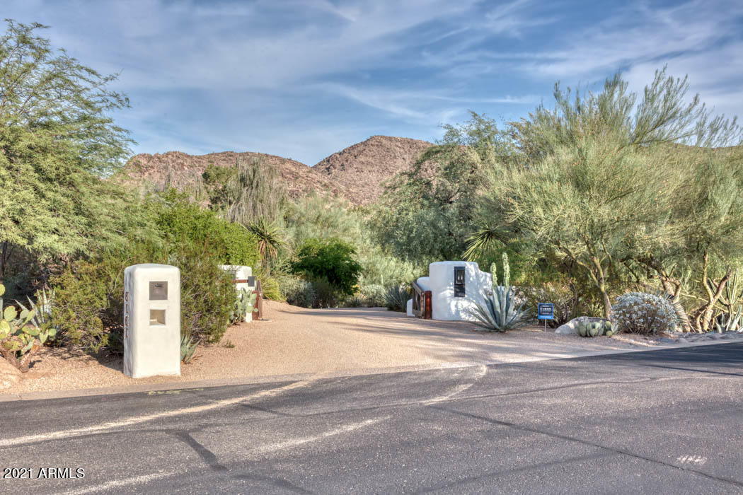 Originally built in 1979 for his own family, artist and architect Bill Tull selected this unique three-acre site to create this ''sculpture for the desert.''  Tull who died in 2000 was a celebrated visionary who built in the Pueblo adobe style.  He created an adobe brick mixed with an asphalt emulsion as opposed to straw to create structural stability.  Homes designed by Tull are strong, romantic, and timeless.  8161 North 51st Place embodies all of the authentic elements of the original home including vigas and latillas, sculptural fireplaces, and thick, smooth walls with rounded corners.  However, this home has been substantially rebuilt and modernized for today's living.  In 2018, the current homeowners worked with Greg Hunt, David Michael Miller, and Berghoff Design to reimagine the... living spaces both inside and out.  The result is a light-filled desert modern home with new electrical systems, lighting, and plumbing.  All bathrooms were remodeled as was the spectacular Bulthaup kitchen.  The master suite was expanded and includes a very large and well-designed his/her's closet. An additional two car garage was added to complement the existing three car garage.  Other additions include, a large laundry room, substantial air-conditioned storage, a dog kennel, and a wine room accommodating well over 2,000 bottle wine storage. Indigenous landscaping includes all varieties of cacti, succulents, native desert trees and flowering shrubbery.  The entire yard watering system was overhauled as was all of the landscape lighting.  A new 63' pool was added creating a dramatic backyard scene in addition to providing a wonderful place to swim laps in total privacy. There are three separate structures on the property including the main house, the pool house/casita, and the gym and guest casita building.  Privately gated, this property is secure and secluded; close to everything Paradise Valley has to offer, yet so quiet and charming, it feels as if it is miles from the nearest neighbor.