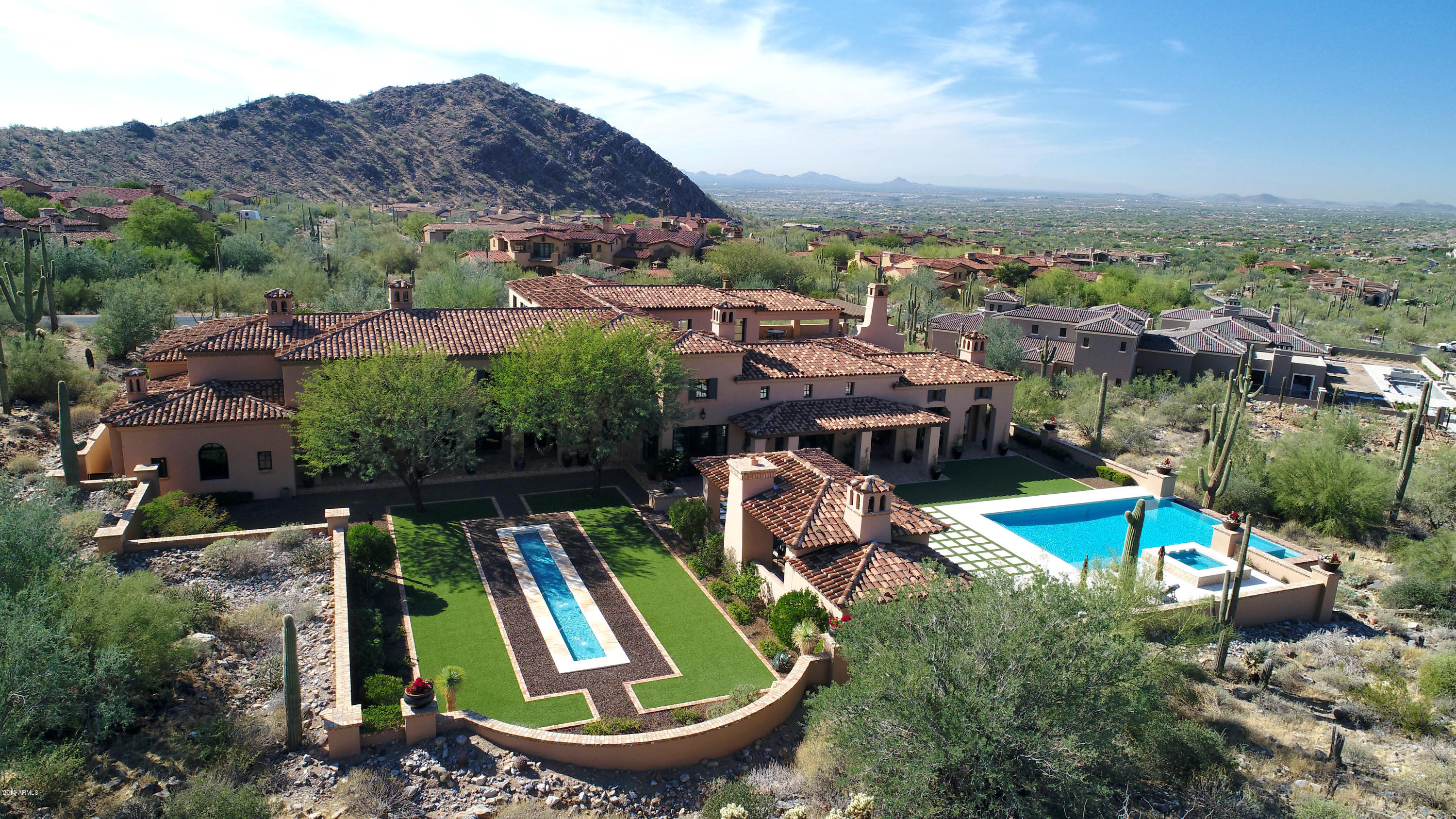 Exceptional location in the Upper Canyon at Silverleaf with generous open space offering panoramic mountain and city views, with desirable easy access to community entry.  Refined estate with extraordinary outdoor living spaces that live inside/out with remarkably sophisticated interiors.  This home is functionally designed and well planned with limitless living spaces, with no interior steps on the main level.  Charming rich hardwoods with Chicago brick detail, grand limestone fireplaces, elegant lighting, complimented by wood and brick ceiling treatments adorn this jewel with timeless style.  Seamless indoor/outdoor living with attached grand covered outdoor living area with fireplace, separate ramada with pool shower, BBQ, living/dining with bench seating, (see ''more'' now) and spacious interior courtyard with BBQ island and fireplace.  Luxurious negative edge pool and spa, meticulous formal garden with linear water feature, generous turf grassy area and covered patios create spaces for all to enjoy.  Relax and revel breathtaking city light views on the upstairs balcony with fireplace, with access from game room with wetbar and courtyard.  Owner's retreat wing offers two flex rooms that can be used as living spaces or bedrooms, private executive office, with two additional bedrooms and baths, media room and game room upstairs, this estate has great living flexibility.  Double island kitchen with Miehle espresso machine, Viking appliances, granite and butcher block accent countertop, Sub Zero double fridge freezer, temp control wine room, bar with additional dishwasher, and workstation desk.  Separate studio guest residence with ample room for living/bed, kitchenette and full bathroom. Distiguishing details include radiant heat bathroom floors, Crestron system, electronic exterior French doors, porte cochere with four car garage, and master closet washer/dryer.  Immaculately maintained for the most discerning buyers.