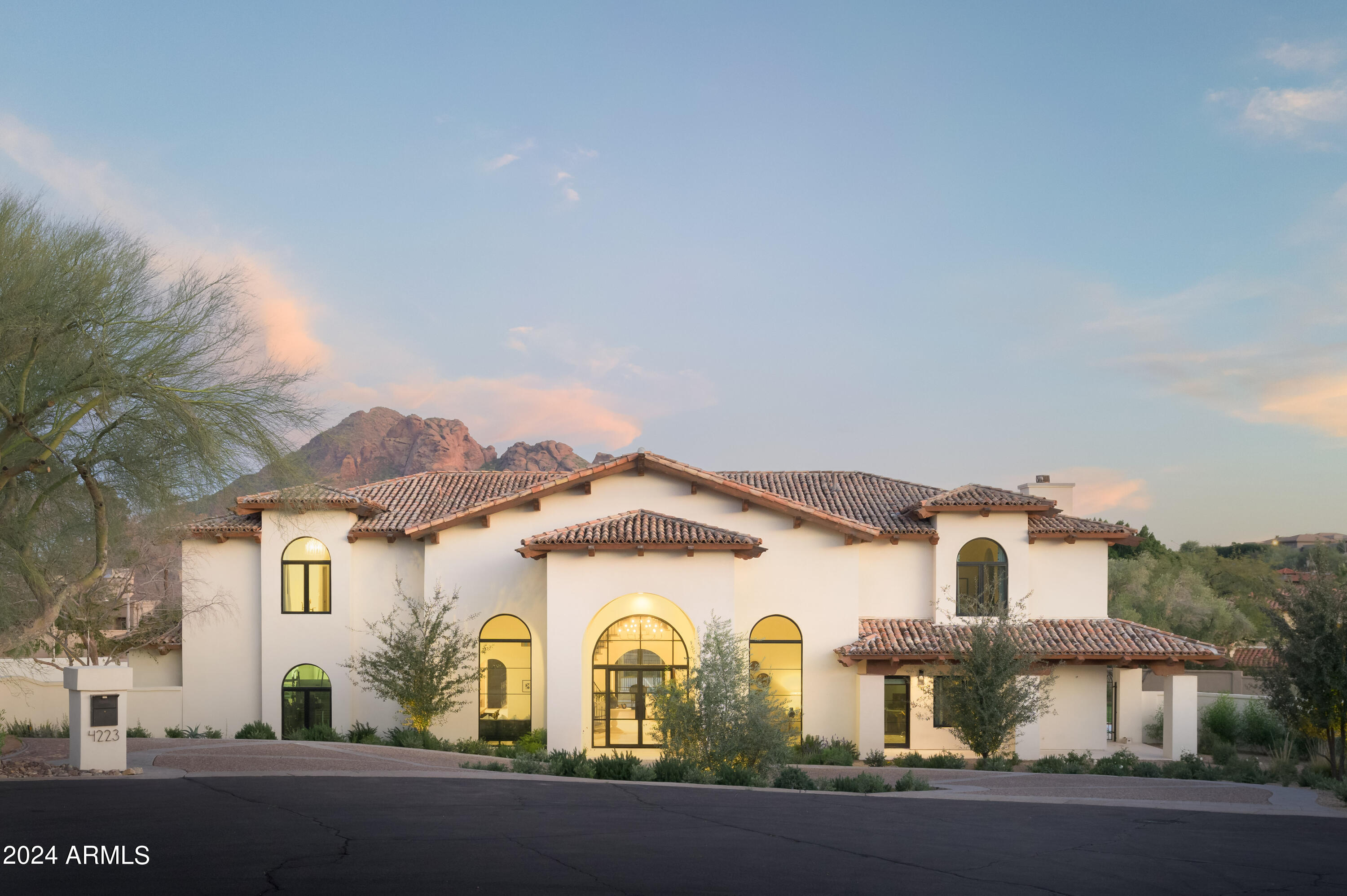 Calm and cool meets crisp elegance in this Santa Barbara style home.   This Paradise Valley property is ideally situated in a private cul da sac in the heart of Clearview Editions, an exclusive gated community offering stunning views of iconic Camelback Mountain.  Completely renovated from the ground up by Arcadia Custom Builders, LLC and fully designed by award winning Katie Bowe Design, this 5-bedroom 5.5-bathroom property features only the finest materials with rich limestone and French oak flooring, natural wood custom cabinetry, and top of the line appliances and hardware. The large kitchen, airy laundry room, spacious bedrooms and common areas showcase contrasting details backed by a neutral color palette. The one-acre estate designed and landscaped by OnSite Landscaping features a large grass yard, glistening pool, sunken tennis court, fire pit, and multiple white limestone patios. Every inch of the 6,288-square-foot home was thoughtfully built to showcase the desert views and maximize indoor/outdoor living. Visit and you'll surely leave feeling tranquil and ready to make the property yours.