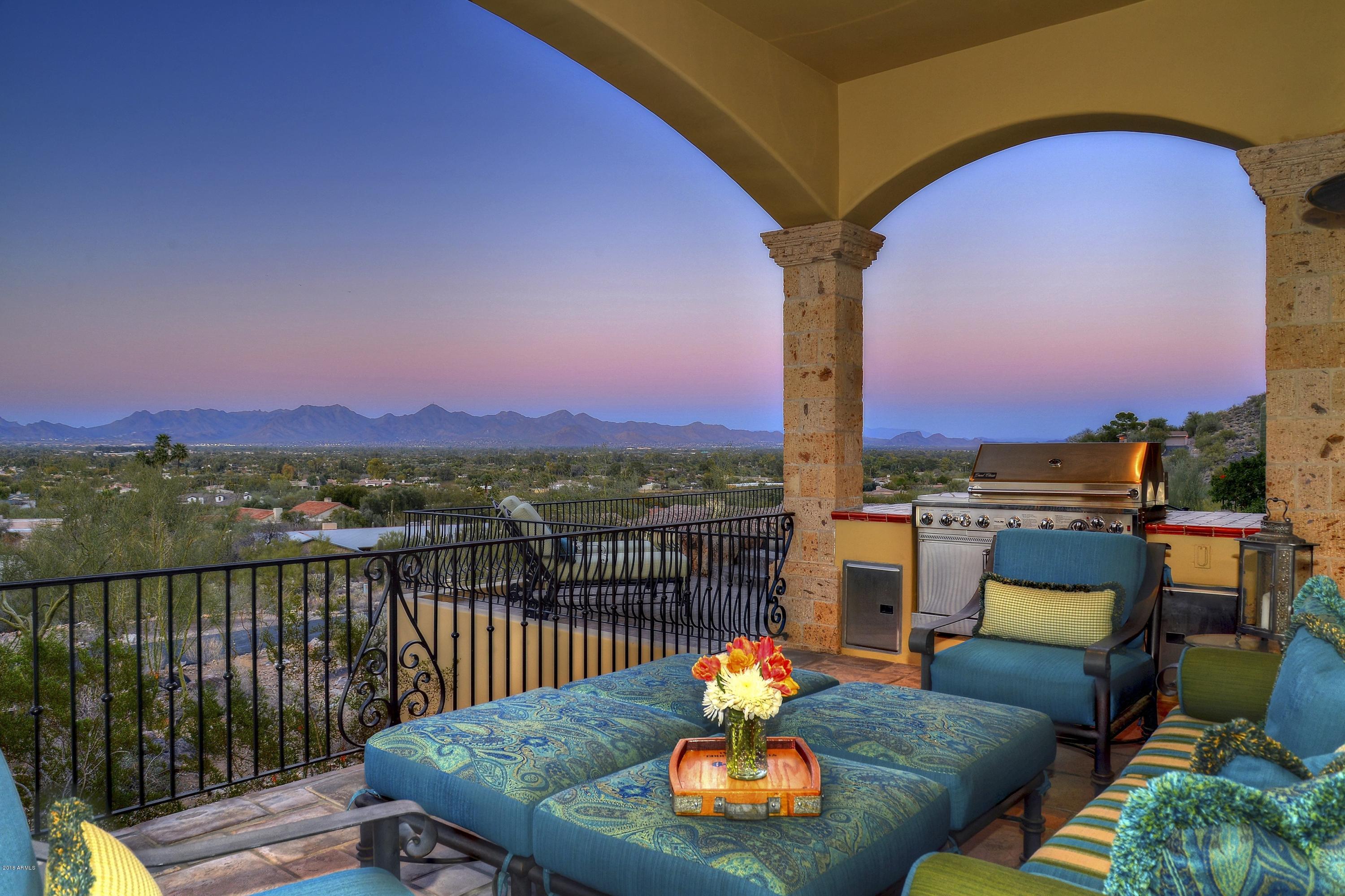 Vista a las Montanas - Named for its spectacular mountain views from every window, this quietly elegant Spanish hacienda sits atop Mummy Mountain's north face, overlooking broad vistas and vibrant city lights.  Imported antique doors, reclaimed wood flooring, hand-carved cabinetry,& vintage European fixtures add an air of artistry and romance to this all block construction custom residence.  ​The square footage is impressive, yet the home feels intimate, warm & inviting. The views are breathtaking, seen across the entire window walls to the north.  Closer mtn. views are visible from individual ​rooms.  The Bar/Game Room offers an authentic antique carousel installation, the craft room is where the creativity begins!  Never before on the market until now.