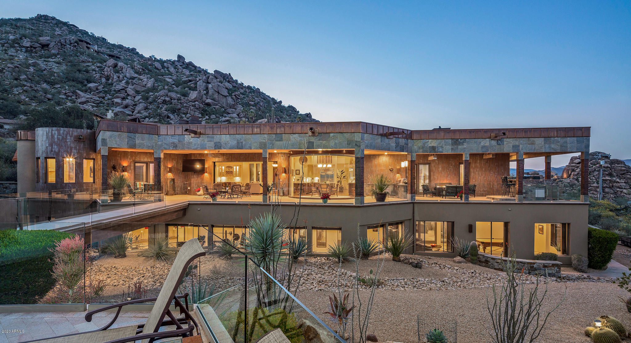 Black Mountain hillside sanctuary. Private, but still close to shopping and restaurants. Mountain, city-light and valley views from the entire house. Floor to ceiling, butted edge glass with retractable glass sliders, afford the ideal inside / outside Arizona living. 6 generously sized en suite bedrooms in the main house, each with private access to the 2,200 SF granite paver patios, with frameless glass. Detached guest house with separate entrance. 70 kW solar that makes the APS bills incredibly low. 3-car upper and 6+ car lower garage with AC. Both the upper & lower garages have Tesla charging stations. Full theater with 10' screen, game room, gym, upper and lower kitchens, and an executive office with separate entrance. Control4 smart home. Quick closing available.