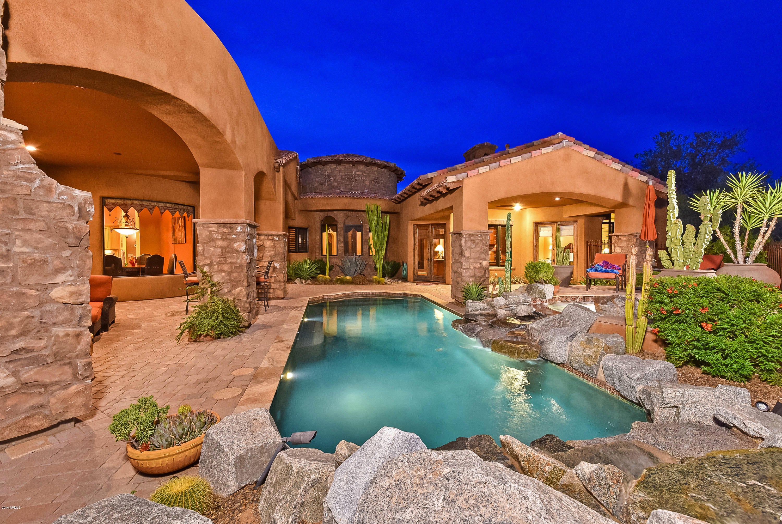 A feature rich, Italian inspired home located in the gated community of Troon Fairways, this detail-oriented custom is magnificent. The four-car, 2,000 sf oversized garage can be accessed two ways and features a large workshop, built-in table tops and cabinetry, additional slab space for washing and epoxy flooring. A motor enthusiasts dream! Sitting on a ¾ acre private lot enjoy Troon Mountain views from the resort style backyard with inviting pool and spa and large covered patio with fireplace. Inside the home is a masterpiece. A gourmet kitchen with stunning granite counters, two-toned island, crown molding, tile accents, and top-of line stainless steel appliances. In the large master suite with sitting area enjoy your soaking tub walk in shower and double vanities. Other features: venetian plaster, barreled and beamed ceilings, arched windows, hand carved Canterra fireplaces, Versailles pattern travertine floors with chiseled edges, plantation shutters, lighted onyx bar, built in exterior bar and bbq, and gated courtyard with centerpiece fountain.