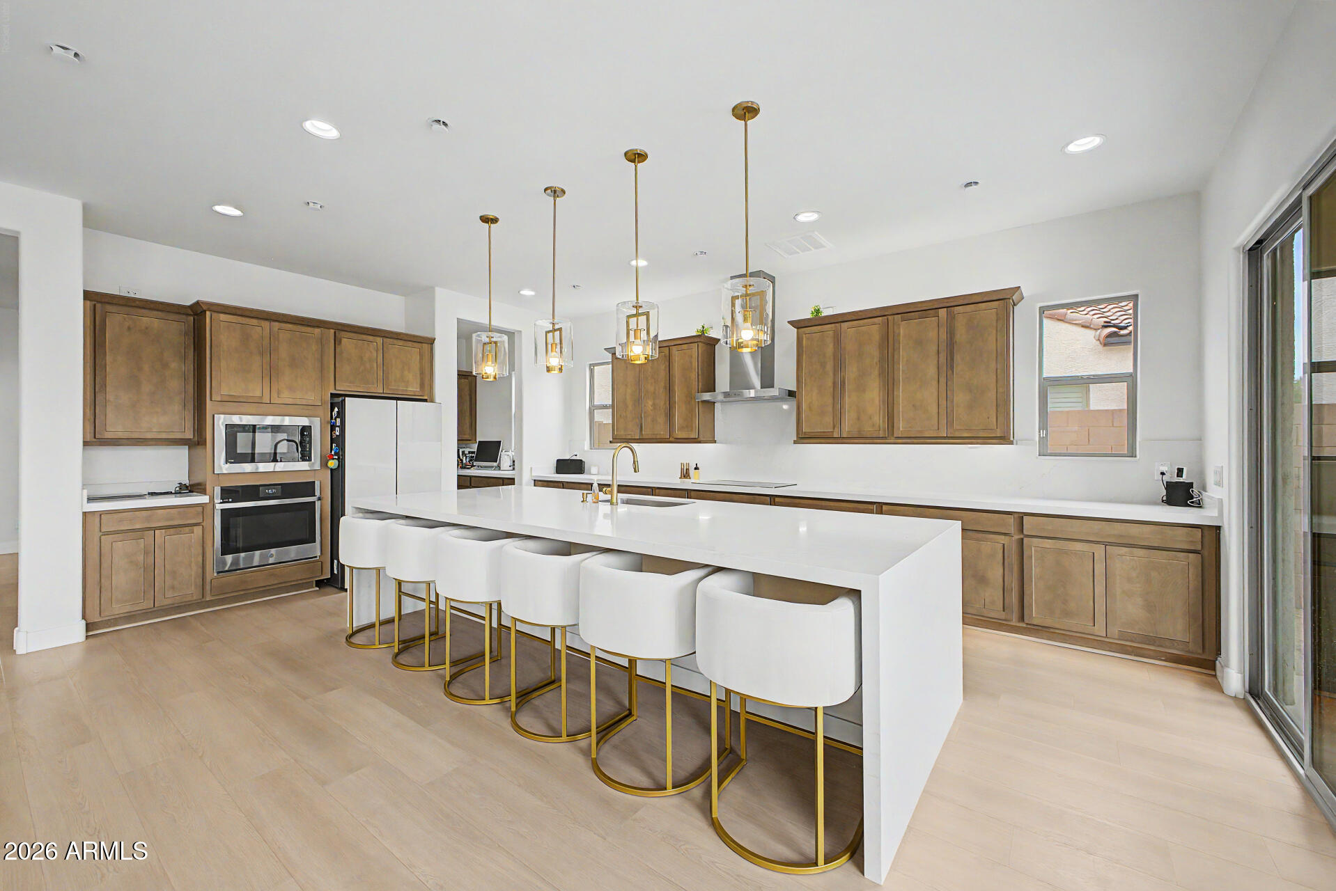 Truly exceptional 2025 residence in the gated Village at Thunderbird, ideally located near major healthcare centers & large employment hubs across the northwest Valley. Light-filled open floorplan w/ soaring 10-ft ceilings downstairs, 9-ft ceilings upstairs, & 3 large dual sliding doors opening to an expansive covered patio. Stunning chef's kitchen features quartz waterfall island w/ seating for 6, gleaming SS appliances, induction cooktop, custom lighting, butler pantry, huge walk-in pantry. Spacious ground-floor guest suite w/ full bath. Luxurious upstairs primary suite, 3 additional ensuite bedrooms, large loft. Energy-efficient high-velocity HVAC delivers superior comfort year-round, while a large private backyard offers endless potential for resort-style pool and custom landscaping. Enjoy relaxing with a cup of coffee in your spacious, inviting front courtyard!  Home features a large, convenient upstairs laundry room with high end energy efficient washer and dryer.  Very spacious four car tandem garage provides a huge amount of parking and storage space.  The downstairs guest suite with full bath offers ideal flexibility for visitors or multigenerational living.  The location of this elegant home is especially attractive for healthcare workers, aerospace employees, logistics workers, and professionals commuting to north Phoenix employment corridors because of the strong freeway connectivity nearby. Major medical facilities nearby include Banner Thunderbird Medical Center, Abrazo Arrowhead Campus, and St. Joseph's Westgate Medical Center.  Major employers close to this beautiful community are Banner Health, Abrazo Health, Midwestern University, Honeywell Aerospace, USAA, and the new TSMC manufacturing campus.   Also very close to endless shopping, dining, and entertainment.  Truly an exceptional residence in a gorgeous new gated community.