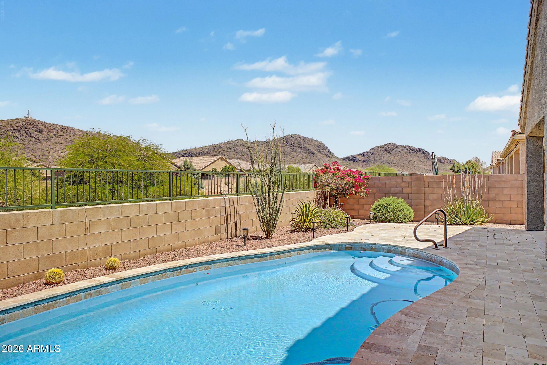 From the moment you step through the front door, your eyes are drawn straight down the hallway to the double glass sliding doors, where a breathtaking backdrop of mountain views instantly steals the show. This beautifully designed 2 bedroom plus bonus room, which could easily serve as a third bedroom or private office, offers 2.5 baths and is located in the gated 55 plus community of Saguaro Springs. As you move into the heart of the home, the great room opens up with tile flooring, soft neutral tones, and natural light pouring in from the wall of glass. The kitchen is both functional and inviting, featuring granite countertops, stainless steel appliances, a pantry, rich cabinetry with crown molding, and a large center island with breakfast bar seating, perfect for casual dining. The primary suite is tucked away for privacy, offering plush carpet, a generous walk-in closet, and a well-appointed bath with dual sinks. A secondary bedroom and additional full bath provide comfortable space for guests.
Step outside, and the view only gets better. Enjoy a covered patio, paver seating area, and a sparkling pool, all set against those incredible mountain views that make every sunrise and sunset feel wonderful. This is the kind of home that feels right the second you walk in.