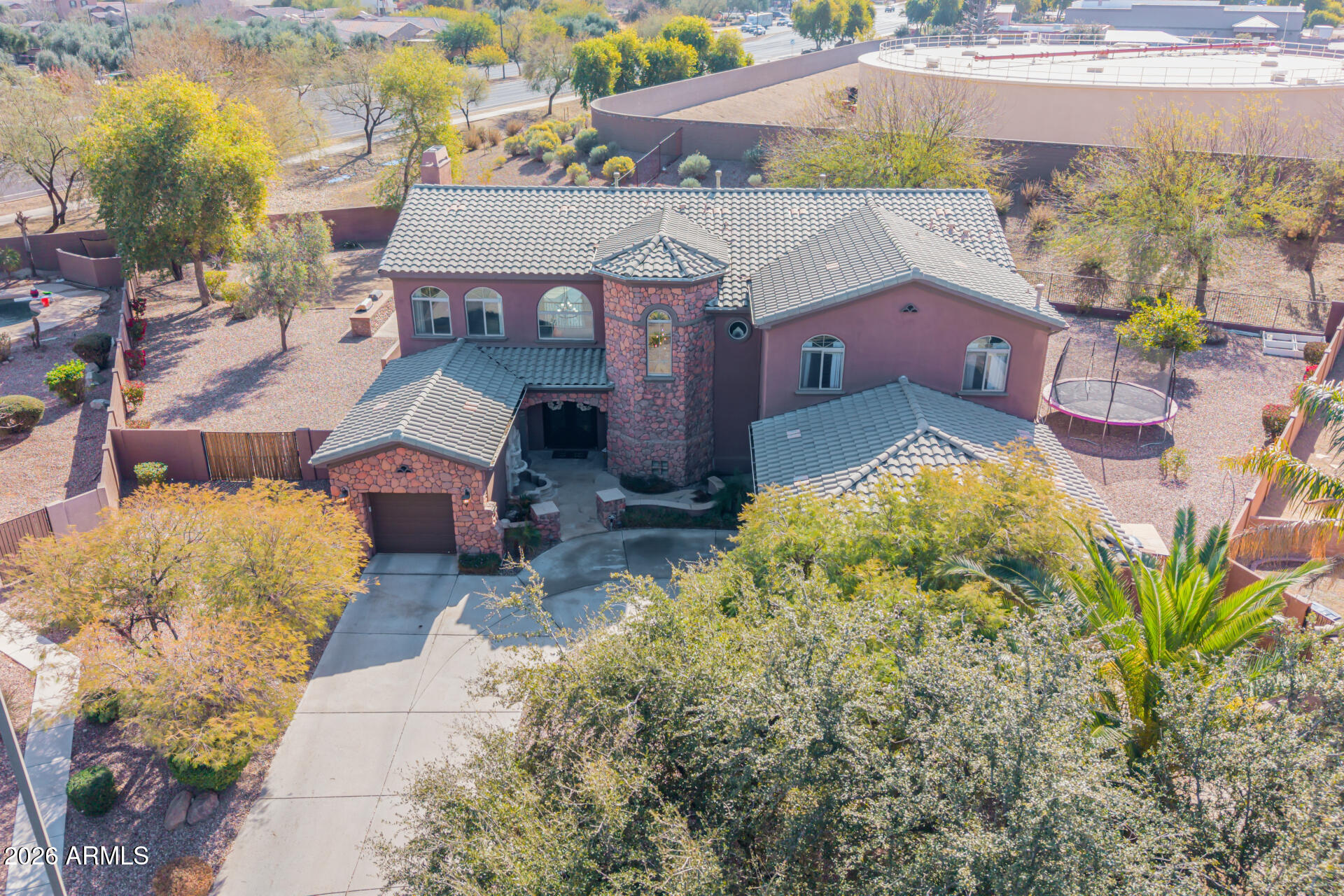 This stunning tri-level home awaits you in the desirable Power Ranch! The beautiful stone-accented facade, 3-car garage, and charming landscape are just the beginning. Step inside to fall in love with the bright and airy living areas, showcasing a perfect blend of elegance and comfort, with pristine stone-like floors, double tray ceilings, modern light fixtures, a stone fireplace to add ambiance to your gatherings, large windows to offer plenty of natural light, beautiful arched passageways, and an earthy palette throughout that makes every space feel warm and welcoming. The kitchen is a chef's dream, equipped with custom cabinetry, quartz countertops with a matching backsplash, stainless steel appliances, and an expansive island with stone accents, perfect for entertaining and casual meals. The lavish main bedroom is a true retreat, offering a spacious sitting room, a spa-like bathroom with luxury touches throughout, including an oversized dual-sink vanity, a built-in makeup table, a walk-in shower, and a soaking tub. This gem is an entertainer's delight, as it features a home gym and a home theater.  The backyard oasis is complete with two covered patios, plenty of seating space with pavers, a built-in BBQ, a relaxing spa, and a heated diving pool with LED lights. This home truly has it all! You REALLY don't want to miss it!