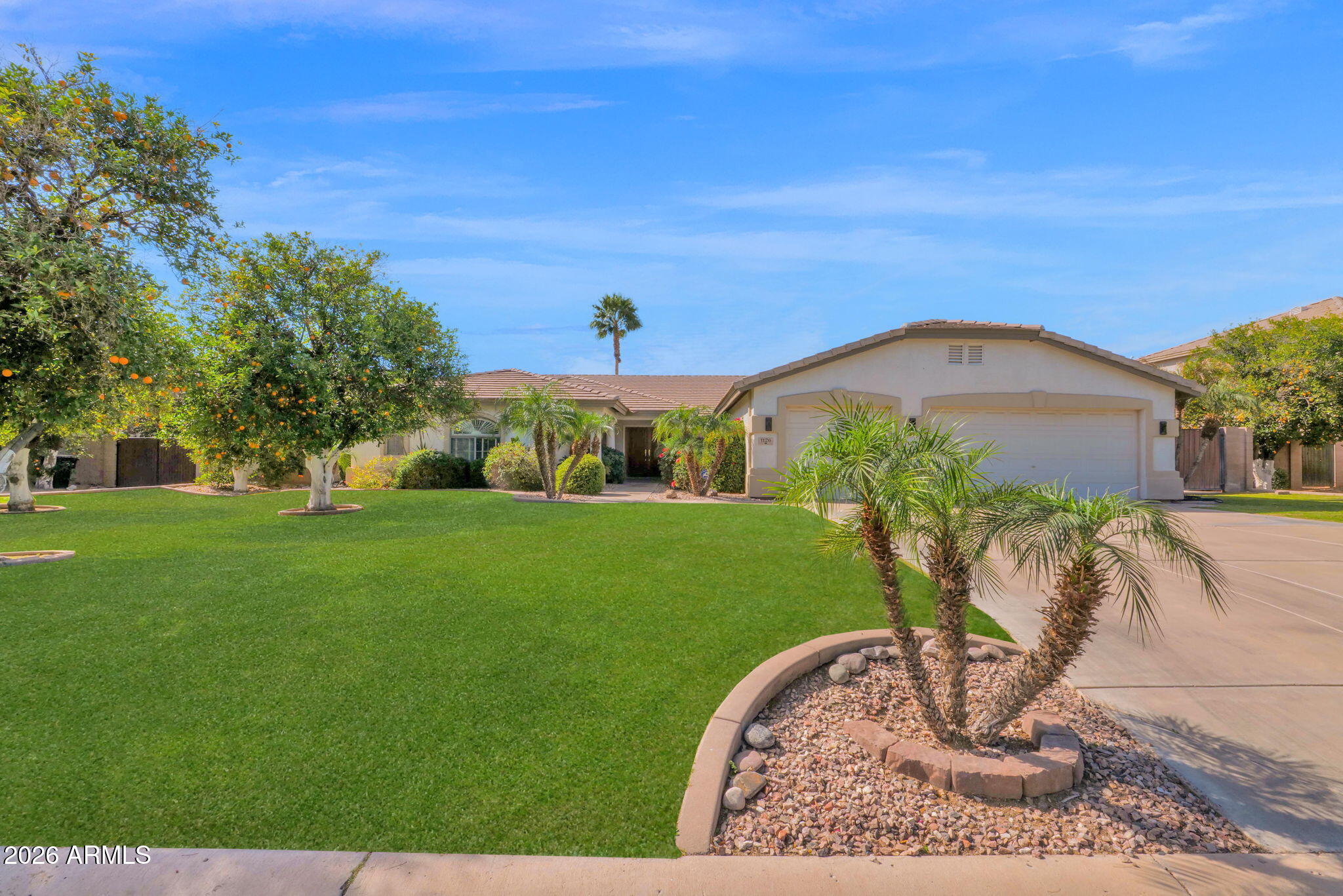 Discover the stunning single-level home you've been dreaming of, nestled on a generous half-acre citrus lot in the prestigious gated community of Mahogany in Mesa, Arizona.

Step inside and be instantly captivated by the grand, spacious, and incredibly open layout that feels warm, welcoming, and full of light. Freshly carpeted living areas and bedrooms add that perfect touch of modern comfort.

The luxurious primary suite is a true retreat, featuring an expansive sitting area, a soothing jetted tub, a separate walk-in shower, elegant granite counters, and an oversized walk-in closet designed for ultimate relaxation and style. The heart of the home is the gourmet kitchen, a chef's paradise boasting sleek granite countertops, a double oven, a brand new GE 5-burner gas cooktop, a new dishwasher, a massive center island with breakfast bar seating, and a convenient walk-in pantry. It flows seamlessly into the inviting great room with its cozy fireplace, creating the ideal space for gathering and everyday living.

Outside awaits your personal desert oasis a private, secluded backyard paradise shaded by a delightful variety of mature citrus trees. Dive into resort-style living with the sparkling pebble-tech pool, complete with a soothing rock-accented waterfall and ample lounge areas. A large covered patio perfect for BBQs, plenty of lush grass for play or relaxation, and a beautiful paver patio offer endless opportunities for entertaining while you soak in breathtaking Arizona sunsets that are simply unforgettable.

Additional highlights include a three-car garage with built-in cabinets and a sleek epoxy floor for maximum functionality and style.

This exceptional home combines space, luxury, privacy, and outdoor bliss in one incredible package your slice of Arizona paradise awaits!
