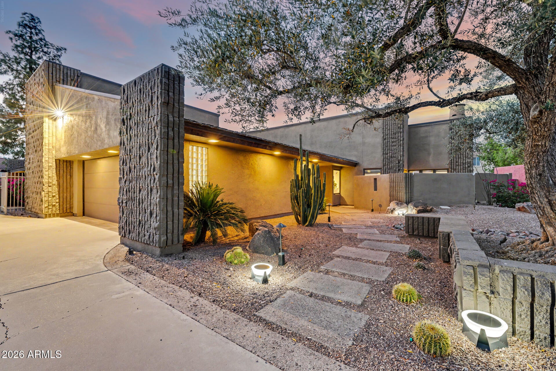 Welcome to a truly exceptional mid-century modern residence in the heart of Tempe, where timeless architecture meets elevated, design-forward living. From the moment you enter, soaring vaulted ceilings with exposed rough-sawn wood beams create a striking sense of volume and warmth--an unforgettable first impression that sets the tone for the entire home. Every detail has been thoughtfully curated to blend clean modern lines with rich, organic textures. At the center of the home, the fully reimagined kitchen serves as both a statement and a gathering place. Featuring honed porcelain countertops, a custom backsplash, and a dramatic waterfall island, the space is designed for effortless entertaining as well as everyday living. Exceptional storage is thoughtfully integrated throughout... including three separate pantry spaces, offering a rare level of organization and functionality. The main living area is anchored by a beautifully modernized fireplace wrapped in quartz and complemented by warm wood accents, creating a sophisticated yet inviting atmosphere. Architectural details are layered throughout, including a custom leather accent wall in the dining area that adds warmth, texture, and a distinctive designer focal point. Refined finishes continue with quartz countertops in all bathrooms and the laundry room. The primary suite is a private sanctuary--an indulgent retreat designed for both comfort and style. The spa-inspired bathroom features dual vanities, a soaking tub, and a custom walk-in shower. Custom built-ins by California Closets enhance the primary bedroom and closet, offering both elevated design and exceptional functionality. A cozy sitting area with its own fireplace and direct patio access provides the perfect place to unwind. Step outside to your own resort-style escape. The backyard is designed for seamless indoor-outdoor living, complete with a sleek pool and a covered patio featuring custom alder tongue-and-groove woodwork and a striking mahogany-wrapped beam. High-end lighting and Haiku ceiling fans--featured throughout the home and patio--enhance comfort and airflow while adding a refined, modern touch. Even the garage has been thoughtfully upgraded, featuring a marbled epoxy floor and its own mini-split system--ideal for a gym, workshop, or climate-controlled flex space. With its strong architectural presence, cohesive modern aesthetic, abundant storage, and meticulously curated upgrades, this home offers a rare, move-in-ready opportunity in one of Tempe's most desirable neighborhoods.