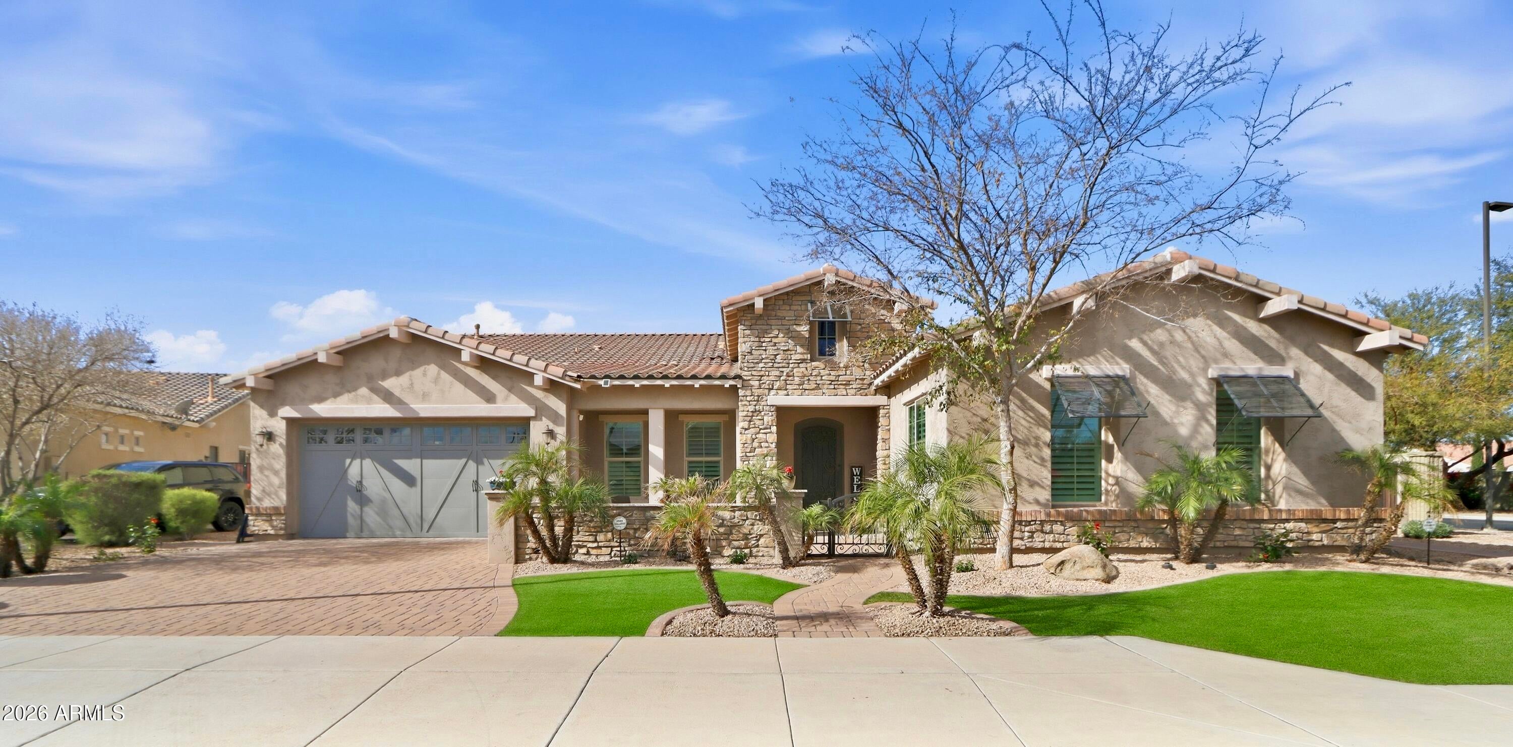 Luxurious Executive Home in the Gated Layton Lakes community of S Chandler. This extraordinary property feels like home from the welcoming front patio to the private backyard oasis. Designed for entertaining, it offers large open-concept indoor living & multiple outdoor spaces for pool parties, relaxing on the sun deck, BBQs with friends, or quiet dinners under the covered patio.
Inside, the stunning chef's kitchen & great room with a dramatic 12-foot coffered ceiling create a seamless space for everyday living. Over $400,000 combined in designer upgrades elevate the home beyond model finishes, including decorator lighting, crown molding, custom woodworking & feature walls throughout. The private primary suite is thoughtfully separated from the rest of the home, offering a serene retreat with a separate keyed entry/exit. A spectacular chandelier leads into the spa-inspired ensuite bath featuring a floor-to-ceiling tiled walk-in shower with bench seating, soaking tub, dual vanities, and two spacious walk-in closets. The suite also offers direct access to the adjacent laundry room for added convenience. The oversized bedroom includes a sitting area & charming window seat- the perfect place to enjoy morning sunshine.
A junior suite at the front of the home offers ideal guest accommodations or a secondary primary option, positioned next to a large bonus/flex room. On the opposite wing, two additional bedrooms are tucked away near the kitchen with a shared adjoining bath. The Living Space also include a a double-door den off the entry, powder bath and wonderful drop zone at garage entry. This Home has so many extras including 3 car tandem with EV Charging, Soft Water System, Hanging Storage, Built-in Storage Cabinetry PLUS a Separate Outdoor Pad for RV/UTV Parking.  Located minutes from the Loop 202 near Downtown Chandler & Gilbert dining and entertainment. Layton Lakes Features Lakes, Streams, waterfalls, equestrian trails, basketball & softball fields, tot lots, BBQ areas, splash park, basketball and lighted tennis courts. A rare, move-in ready opportunity in one of Chandler's most desirable gated communities.