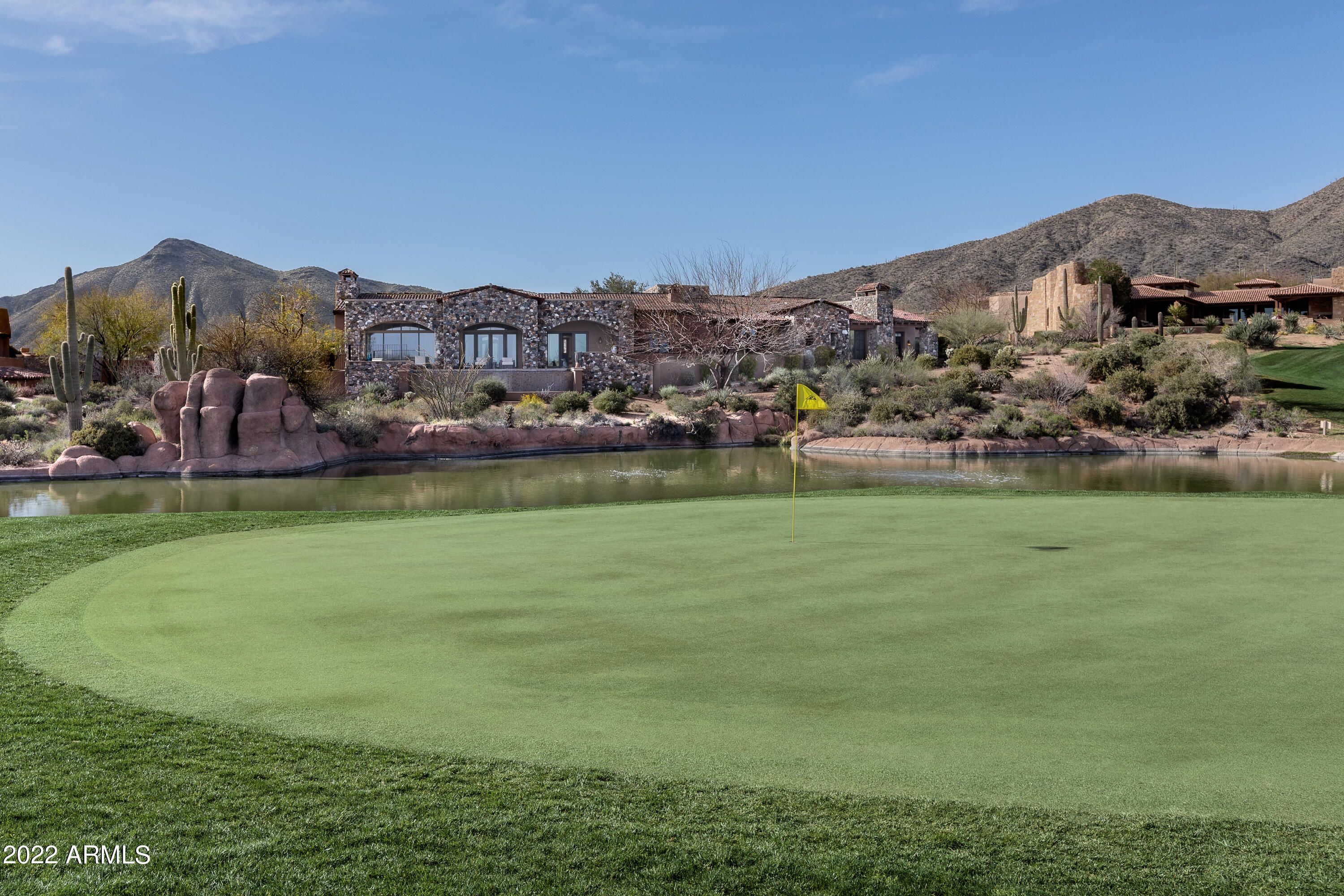 This rare lakeside lot offers an expansive resort style home on the 7th green and lake of the Chiricahua Golf Course in the highly sought-after community of Desert Mountain. Designed by renowned architect, Bing Hu, and tucked at the end of a cul-de-sac, in the Village of Saguaro Forest, this open-floor-plan home boasts Tuscan style architecture with quality finishes throughout including fireplaces, wood beams, venetian plaster walls, reclaimed oak barn wood flooring, travertine stone flooring and stone archways. This spacious 5,983 sq. ft. home offers comfort and style with 4 bedrooms 4.5 bathrooms (including the casita), a grand foyer, an executive office with views to the courtyard, main great room/living room with views to the 7th green/lake, formal dining, family room/informal dining with private patio and fireplaces throughout. The open kitchen boasts granite countertops with two islands, top-of-the-line appliances including a 6-burner gas cooktop stove, breakfast bar, a coffee bar and views of the green/lake. The exterior features multiple private courtyards/patios, sunning/lounge areas near the negative edge pool/spa and a fire pit for golf course, sunset, city light and mountain views. The 3-bay epoxied garage has ample space for your vehicles with built-in storage and easy access to the attached casita. The casita has a custom feel with its private main entrance, comfortable living room with kitchenette area and bedroom//bathroom/walk-in closet with easy access to a private patio with fireplace. This property offers a rare combination of privacy and luxury at one of the best locations within Scottsdale. A Desert Mountain Club Golf Membership is available to be transferred with this property. A 30-day membership application review and approval is required. Contact the Desert Mountain Club for details.