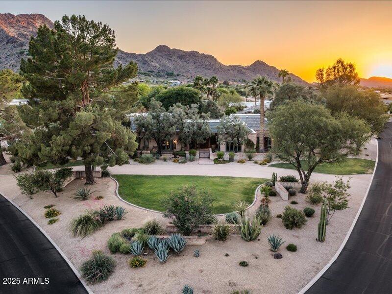 Iconic Bennie Gonzales Masterpiece at the Base of Mummy Mountain in Paradise Valley. A one-of-a-kind architectural treasure blending timeless design with refined modern living. Featured in Phoenix Home & Garden and originally crafted by legendary architect Bennie Gonzales in 1969 and masterfully remodeled by Greg Hunt, this adobe estate offers a rare blend of heritage, craftsmanship, and elegance.

Step through the custom Benny gates entry, personally designed by Gonzales and experience dramatic volume with raised ceilings, Venetian plaster walls, and antique hand-painted doors. Every inch speaks to bespoke luxury, from reclaimed New England oak floors to Loewen metal-clad windows and custom lighting by Creative Lighting Designs. 

The chef's kitchen is a showstopper.. Alder custom cabinetry, commercial-grade Jado 8-burner gas range, and integral concrete countertops. The adjacent butler's pantry features exotic South American wood countertops.

Unwind in the richly paneled primary suite with coffered ceilings, heated bath floors, a steam shower, and a freestanding porcelain-enameled cast iron soaking tub. All guest suites have French doors to the outdoors , a classic Gonzales touch.

Luxuriously appointed, step into a fully detached one-bedroom casita featuring exquisite custom cabinetry, kitchen, and washer & dryer. 

Outdoor living is resort-level with five private patios, an all-tile pool (resurfaced 2021), custom fountains, and lush landscaping framed by citrus, Chinese Elm, and olive trees. Seamless indoor-outdoor integration, a separate guest house, with a full kitchen featuring custom cabinetry, and tiled floors throughout. With expansive garage and storage units to complete the estate.