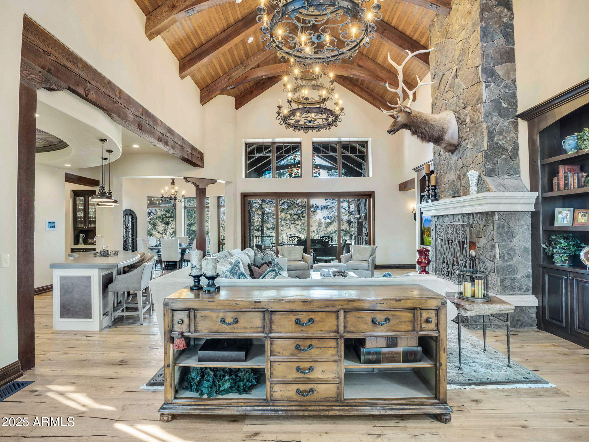 Featuring 4 bedrooms, 4.5 baths, and a large office off of the Primary suite, this masterfully designed single level floorplan sits on one of the most breathtaking lots in Northern Arizona's most premier private club - Pine Canyon, and is truly in a class of its own. At 4,652sqft this one of kind lot offers views of #18 fairway, nearby lake and mountains from the back deck.  The lot, in combination with the custom architecture of the home makes this one of the most peaceful mountain getaways in the community. Upon entering the home, you are greeted by an impressive floor to ceiling stone fireplace, 2 grand chandeliers highlighting the exquisite beam work and tongue and grove ceiling, gorgeous wood flooring throughout and a custom built-in entertainment center.  This open floorplan is perfect for entertaining as the kitchen, living room and dining area flow seamlessly together. Just off the living room is a chef's dream kitchen with 2 separate crescent shaped islands, a custom metal stamped ceiling, Wolf/Subzero appliances, 6 burner range with griddle and dual ovens, Scotsman ice maker, warming drawer, Miele built-in coffee and cappuccino machine, dual refrigerator drawers, full tile backsplash, and a walk-in pantry. Adjacent to the kitchen is a circular formal dining area with an elegant T&G ceiling and more beam work to support the beautiful chandelier all well a beautiful secluded climate-controlled wine cellar with custom metal door sets just steps away. Turning our focus back to the main living area, which leads to a massive covered deck with a full collapsable pocket door system, which is perfect for Flagstaff's desired indoor/outdoor living. Take in the magnificent views from the back deck which also features a floor to ceiling stone fireplace a custom live edge wood mantal, built-in BBQ, and oversized dog run. 
The primary suite has its own private balcony with a porch swing overlooking the golf course, and boasts one of the most luxurious baths complete with a large tiled walkthrough steam shower, separate his and her vanities, makeup vanity, copper soaking tub, two walk-in closets (one with an additional laundry room), and even his/her separate toilets including a urinal. 
On the opposite end of the home there are 3 additional en-suite bedrooms, one with it's on private balcony, and even a fully automated theater room. The state-of-the-art home theater includes comfy leather power recliners with seating for 8, a sound system that rivals large movie theatres equipped with 13 speakers allowing for 2,500 watts of sound, a 140" ultra-high-definition projection system, custom designed acoustic treatments, hand crafted wood paneling, and custom lighting all of which complete the most ultimate cinema experience in your very own home. 
Additional features include, but not limited to, an epoxied 3-car garage with cabinets and a separate workspace, surround sound throughout and Control4 smart home system which gives the owner the ability to control the homes lighting, sound, security and comfort from one location as well as set their own unique moods whether daytime, nighttime or entertainment settings. 
This home is being sold with almost all the furnishings, and is move in ready. This is the ultimate tranquil mountain retreat.