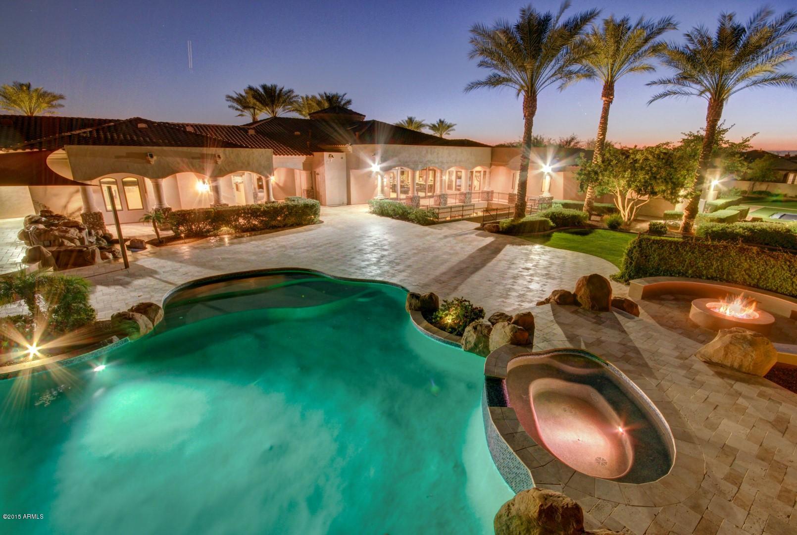 Luxurious Custom Gated Estate nestled against the mountains in the Northwest Valley! Uniquely designed and built for a former Professional Baseball Player. Custom Built, wrought-iron arched double door entry is just the beginning of what this incredible home has to offer. Grand Foyer with custom medallion inlay floor leads into the Formal Dining Room. Coffered ceilings, designer color palette, Turkish travertine flooring, upgraded lighting and window treatments. Gorgeous Gourmet Kitchen features Built-in Viking appliances, two center islands, granite countertops, breakfast bar and plethora of upgraded Alderwood cabinetry. Perfect gathering place for family and friends. Butler's pantry, wet bar, and Den/Office with built-in cabinetry and desk areas. Canterra Stone fireplace, Private Movie.. Theater with plush seating and even a karaoke stage! Personal  and tasteful design touches throughout. Large laundry room with additional storage cabinets. Plush neutral carpet in all the right places.  Private courtyards, two gas fire pits, fountain, and decorative balconies. Sea of travertine pavers surrounds the Resort-Oasis Style backyard with a gigantic sparkling pool, water slide, spa, putting green, in-ground trampoline, synthetic grass whiffle ball field, multi-use sport court and endless Mountain Views. This home also boasts it's own private fitness gym and Indoor Batting Cage!!  Outdoor Kitchen with granite countertops and brushed travertine tile. There is obviously way too many details to list, but this is an Entertainer's Dream home and 100% Move-In Ready!!