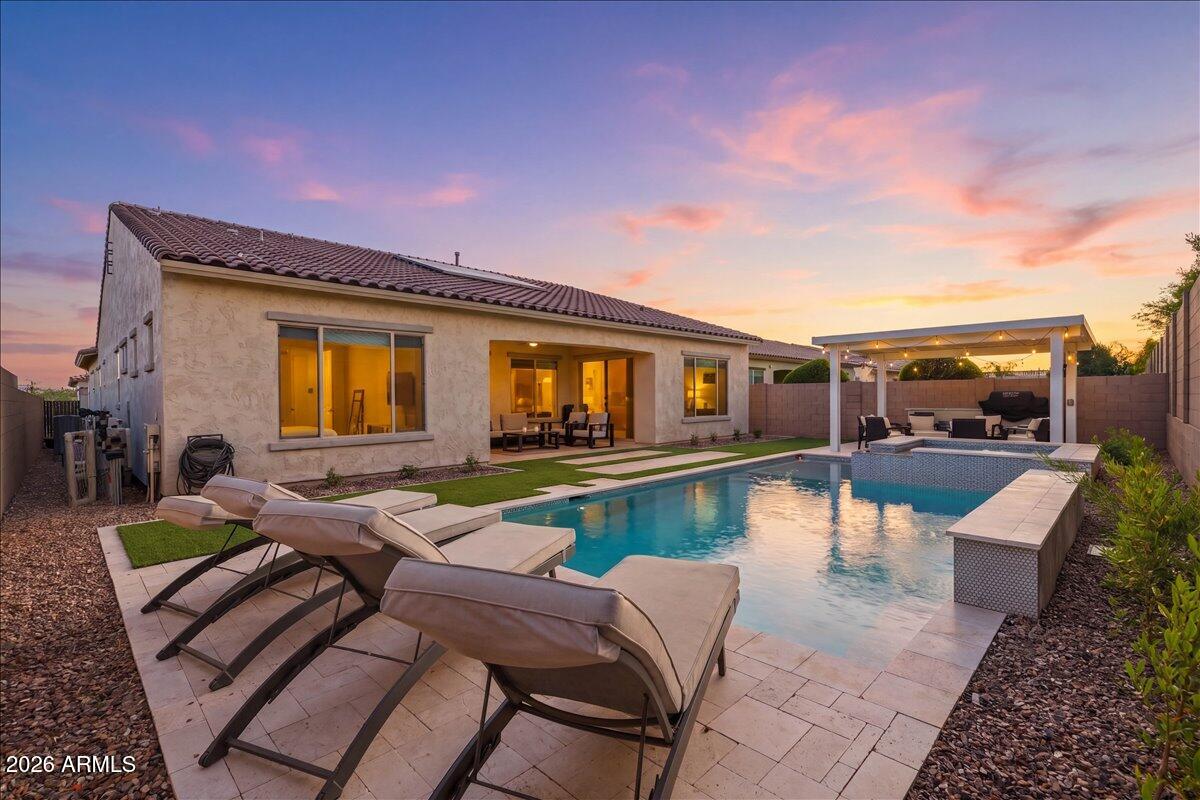 Pride of ownership shines throughout this beautifully upgraded home, offering the perfect blend of comfort, style, and functionality. Located in the gated community of The Estates at Eastmark, residents enjoy access to a community pool and a well-maintained neighborhood setting. With no neighbors on one side, the property offers added privacy and a more serene setting.

This thoughtfully designed split floor plan features 10ft ceilings throughout, three spacious bedrooms plus a versatile office/den, ideal for modern living. Each bedroom includes its own ensuite bathroom and oversized closets, providing exceptional comfort and convenience. The office/den is beautifully built out, creating a cozy workspace or inviting reading retreat. At the heart of the home, the chef's kitchen impresses with expansive quartz countertops, upgraded upper cabinetry, and premium Monogram appliances--perfectly suited for both everyday cooking and entertaining guests.
Unwind in the inviting living room or retreat to the primary bedroom, where you can cozy up by the fireplaces--perfect for adding warmth and ambiance on cooler evenings.
Step outside to your private backyard oasis, where a sparkling pool is paired with a thoughtfully designed gazebo with a dedicated BBQ area and built in gas fireplace--ideal for relaxing or hosting gatherings year-round.
This home also emphasizes energy efficiency and sustainability, equipped with Tesla solar panels, with two powerwall battery backups for added peace of mind, and an EV charger conveniently located in the garage.
NO detail has been overlooked in this home! Enjoy custom blackout Roman shades in the bedrooms, built in drop zone, built in bunk beds, epoxy garage floors, storage racks in the garage. This home has it all!