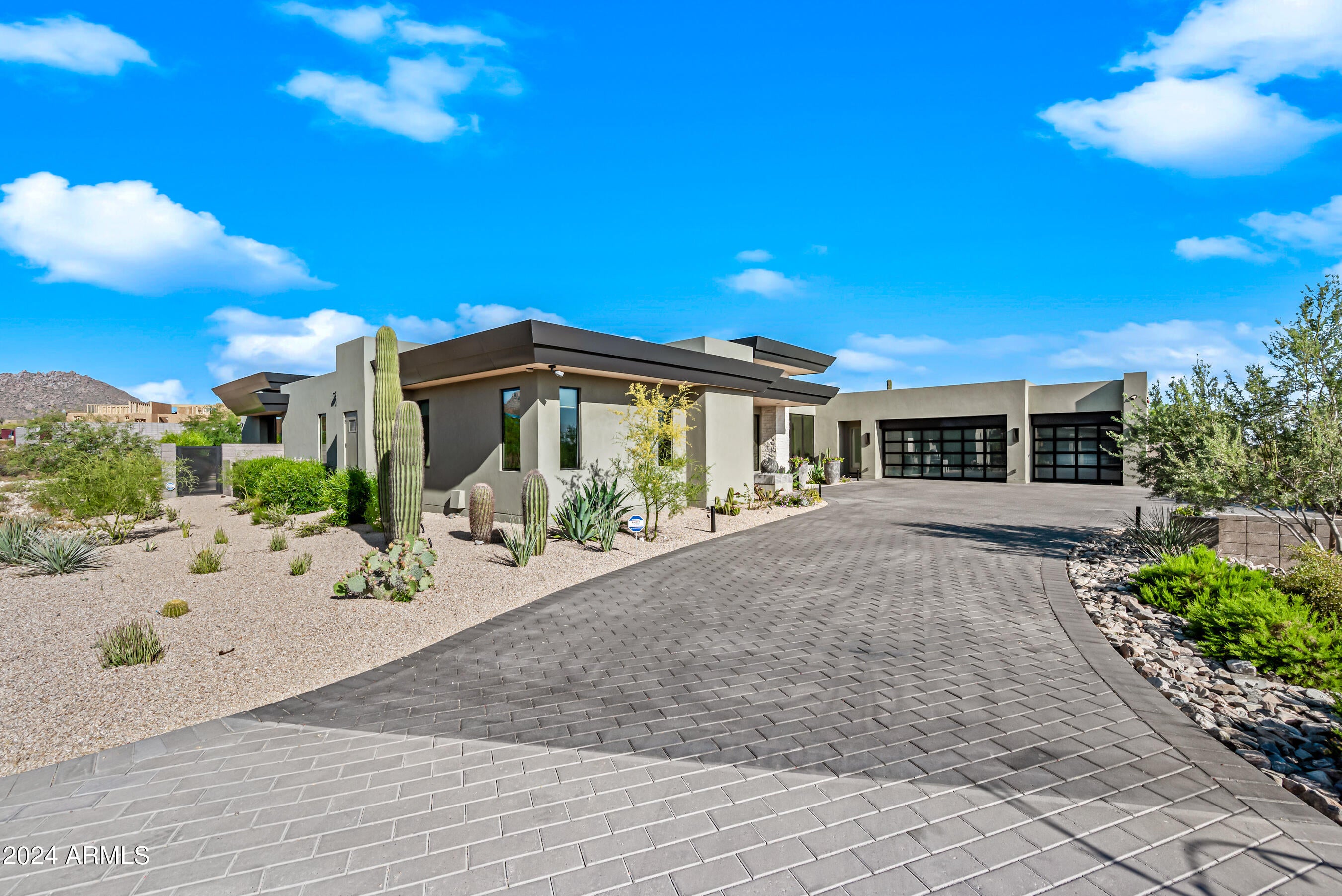 Discover luxury living in North Scottsdale with a NEW HOME in Solitude. Breathtaking single level retreat is simply defined as, PERFECTION with an owner that is meticulous to detail, none smoker and no pets. As you arrive to the exclusive gated community, your experience of this Desert Gem begins as you enter the home, with its enchanting spa like energy trough the breathtaking entry door with glass floor to ceiling. Entering the home you cannot miss the sliding glass doors, opening out to the breathtaking zero-edge pool with two water features and expansive covered patio & ramada offering the ultimate resort setting. The home was Designed to seamlessly blend indoor and outdoor contemporary luxury living, the great room features a custom fireplace with a chiseled black tile surround No detail was left out even the roof eves done with matching the interior tongue-and-groove Alder. The gourmet kitchen boasts two sprawling white marble islands with waterfall effect, Wolf commercial range, separate Subzero refrigerator/ freezer/ ice maker and Asko dishwasher looking out to the entertainers dream Great room with bookend floor to ceiling "Valhalla" Quartzite Leathered fireplace and resort back yard. The primary suite is a private haven with views of beautiful pool and water features, a custom tiled fireplace, and on suite with fully tiled walk-in steam shower. The secondary oversized bedrooms include two generous ensuite bathrooms, a bonus flex/media room, and a laundry room with hair sink. Outdoors, indulge in a zero-edge pool, back fire wall, firepit, bocce ball court, and fully covered ramada with bathroom, Misters, ceiling fans, built in heaters and fully equipped built-in BBQ area with a pop-up TV that hides away! This residence is a meticulously crafted haven, where every detail enhances the Contemporary luxurious lifestyle offered in the heart of 85255.