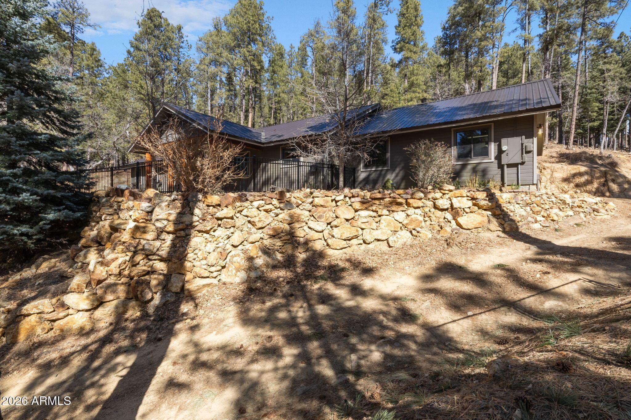 Escape to your own private mountain sanctuary nestled among Prescott's towering Ponderosa Pines. Perched on 2 acres of natural Arizona mountainside, this hidden gem offers the seclusion, scenery, and modern comforts most only dream about. The 2,044 sq. ft. home features 3 bedrooms, 2 bathrooms, raised ceilings, and a 3-car garage, perfectly suited for full-time living or a true weekend retreat. Over $200,000 in upgrades means move-in ready from day one, including a new metal roof, Andersen windows, Prestige security doors, plank flooring, porcelain kitchen tile, stainless steel appliances, updated dual-fuel HVAC system, newer water heater, whole-house backup generator, and high-speed Starlink internet availability. The kitchen is thoughtfully equipped with a propane cooktop, electric oven, newer microwave, and dishwasher for the perfect blend of efficiency and convenience. Outdoor features continue to impress with a fenced front yard with 3 gates, established drainage landscaping, a started workshop pad, RV parking with water and electrical hookups, and 220 electrical already installed at the backyard ramada for a future hot tub setup. The well produces an impressive 15 GPM, with septic certification and survey already completed for added peace of mind. Whether you're seeking a peaceful mountain escape or a full-time home surrounded by nature, this property offers the rare combination of privacy, infrastructure, and everyday comfort.  Experience the magic of this mountain retreat in person!
