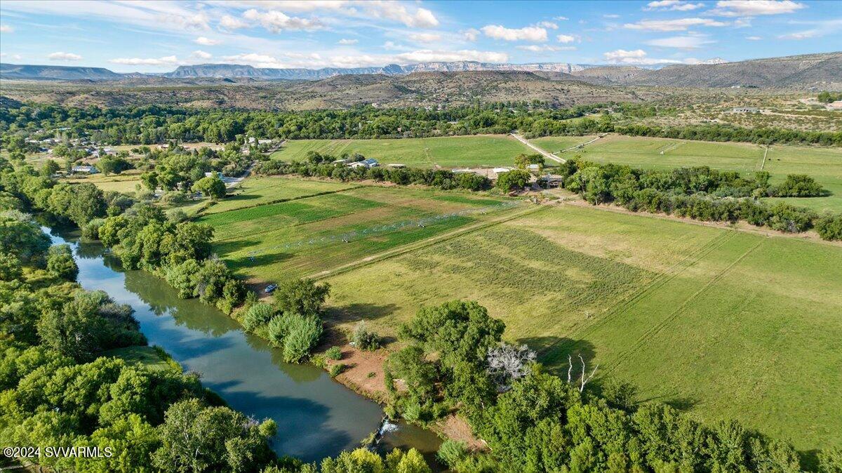 A once in a lifetime opportunity to own the beautiful historic 70 acre Tres Hermanas Ranch located in the heart of the Verde Valley wine country - a breathtaking gated creek front estate known as the ''Emerald'' of Cornville, Arizona.  Are you looking for a serene place of beauty away from city life where the only deadlines are set by the rising and setting of the sun?  Located on the banks of Oak Creek, the property features a beautiful ranch home with redwood siding and pastoral views of the creek front pastures and greenbelt, a large hay barn, caretaker's apartment, a greenhouse, an 8 stall horse barn, a pond, all in the midst of majestic 100+ year old trees offering shade and the inspiration of nature.  It comes with abundant historic water rights of 444 acre feet annually. The property enjoys the abundance of 443 acre feet of historic water rights from the Mason Lane Ditch, a diversion of Oak Creek, dating back 1898.  The property includes a warm and well maintained 3650 sf 4 bedrooms / 2 baths ranch home featuring pastoral views of Oak Creek below. The property also includes a 4000 sf hay barn / workshop with a 640 sf caretaker's apartment, a center aisle 8 stall MD barn of 1760 sf with runs, 8 covered pipe stalls, a round pen, a 2000 sf greenhouse, a root cellar, solar power, a private well w 12000 gallon storage tank capacity, irrigation pivots, perimeter fenced with multiple fenced off pastures for feeding rotation.  Are you thinking Dude Ranch, Fishing, Hiking, Equestrian Retreat, Family Retreat or any retreat calling for the inspiration of the earth and nature?  This is your place. The property includes 6 parcels:  407-32-025L, 407-32-025X, 407-32-025Y, 407-32-057, 407-32-025Z, 407-32-025V.   Located 18 min to Sedona, 15 min to Cottonwood, 5 min to the designated scenic and historic highway of Page Springs Road and its wineries and restaurants, 1 hour 45 min to Phoenix Sky Harbor Airport, 50 min to Flagstaff Pulliam Airport.  All livestock and farm equipment is negotiable.  Shown by appointment only.