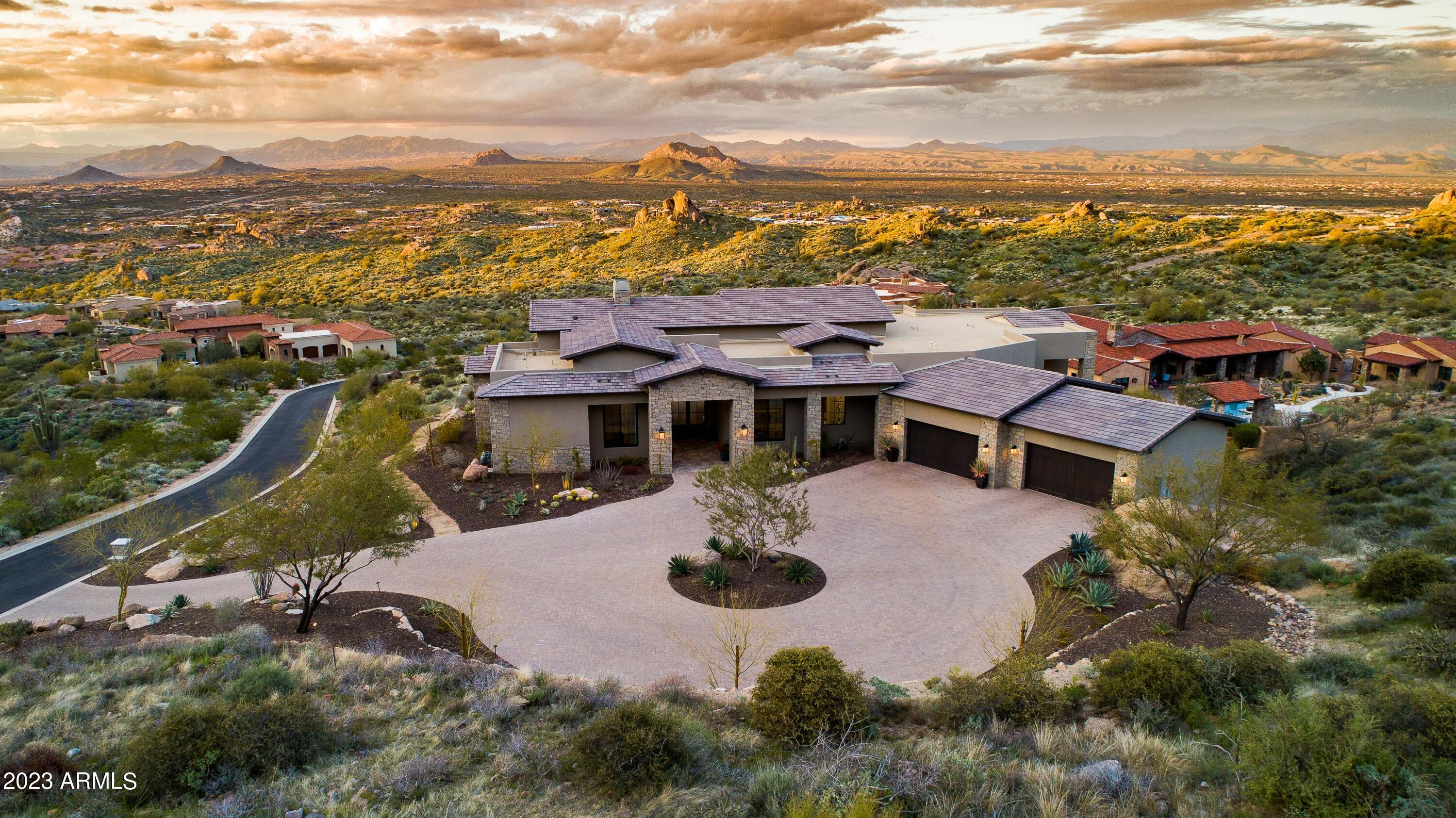 Rare opportunity to live in a breathtaking home and location, providing the optimal blend of luxury, serene privacy and unparalleled views.  Situated in The Estates at Miramonte, perched atop one of the highest elevation lots in the area with a north/south orientation, this transitional custom 2.5 acre retreat built in 2019 is settled on area rock croppings and surrounded by spectacular views of the city below, fabulous sunsets and surreal mountain views.  Meticulously crafted with the highest quality materials and finishes that embody luxury and comfort, this 4-bedroom, 4.5 (ensuite) bathroom plus den and office design will make your spirit dance.  A double gated entry leads to the property, with a paver circular drive setting the stage to enter through modern French doors with glass panes, the custom wood floor in the foyer leading throughout the main living areas accentuated by custom chandeliers and 15-foot coffered ceilings.  Automated retractable doors seamlessly bring the outdoors into the open design, complete with custom Wine Guardian 408 bottle temperature-controlled glass wine wall, bar with beverage storage, ice maker and custom built-ins for display and storage.  Entertaining never felt so sublime.  The great room fireplace, finished with custom wainscoting, is a welcome gathering spot for cool desert evenings, with views from the bar, formal dining room and kitchen.  The kitchen offers premium appliances (Wolf, Miele, SubZero) and additional touches such as built-in Miele coffeemaker, steam oven and warming drawer, completed by natural quartzite counters, marble tile backsplash, oversized breakfast island and custom Burdette cabinets.  The outdoor space is truly an extension of living with a sunken "living room" complete with outdoor fireplace and firepit, outdoor kitchen with built-in barbeque and pizza oven, putting green, multiple lounging areas, fire elements, spa and the crème de la crème of negative edge pools with mesmerizing views.  Not to be overlooked, the 4-car garage with temperature-controlled storage, epoxy floors and built-in cabinets is the perfect refuge for toys. The amazing finishes and features of this home are endless, grab your opportunity to bring the resort lifestyle home.  Special offer, Mirabel golf membership is available for separate purchase as part of purchasing this home.